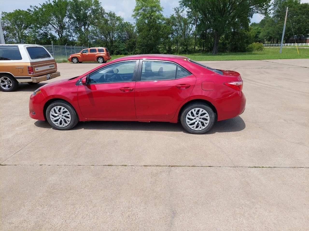 A red car is parked in a parking lot