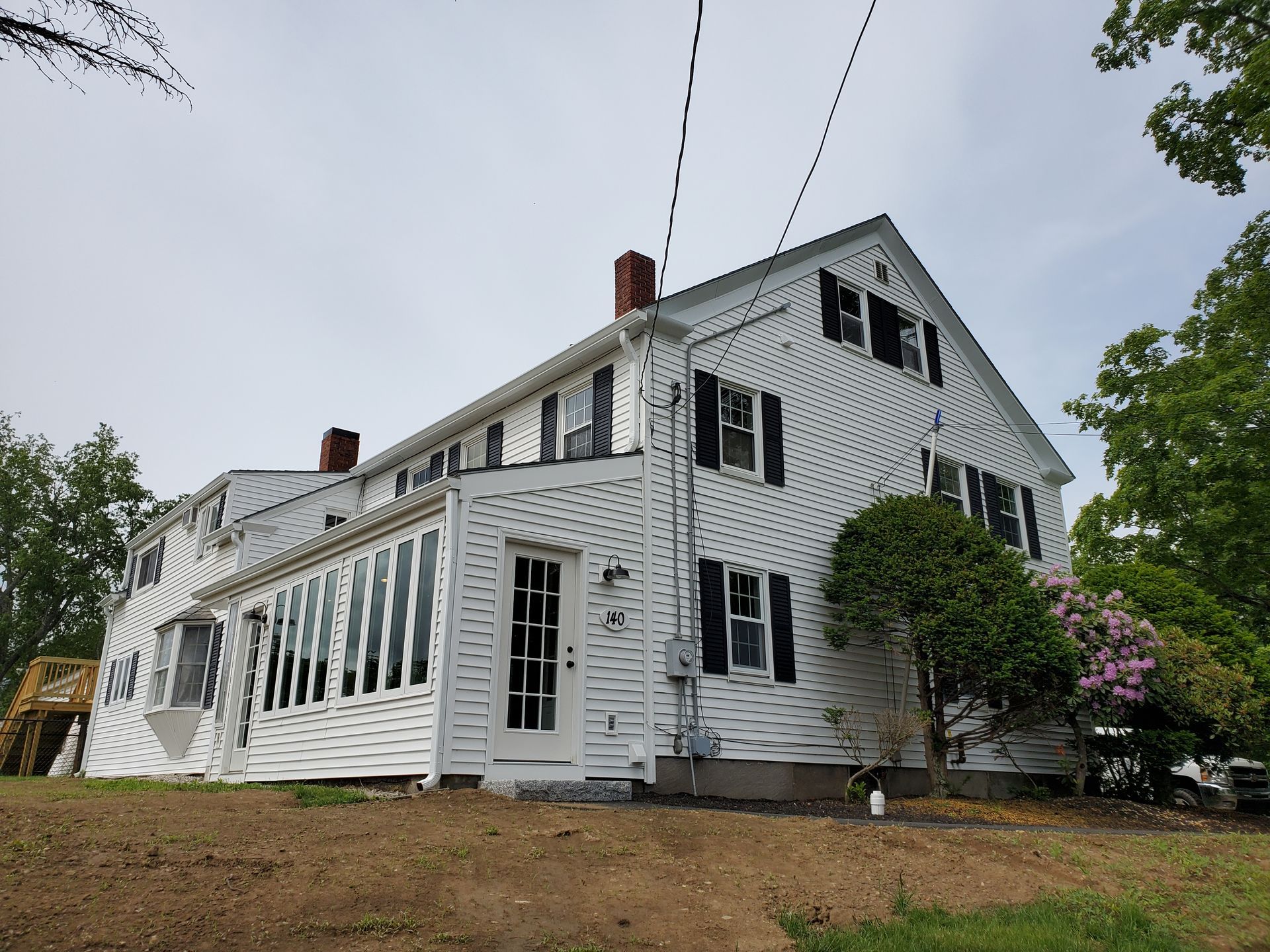 140 Pleasant Street Epping NH Apartments in a large white house with black shutters.
