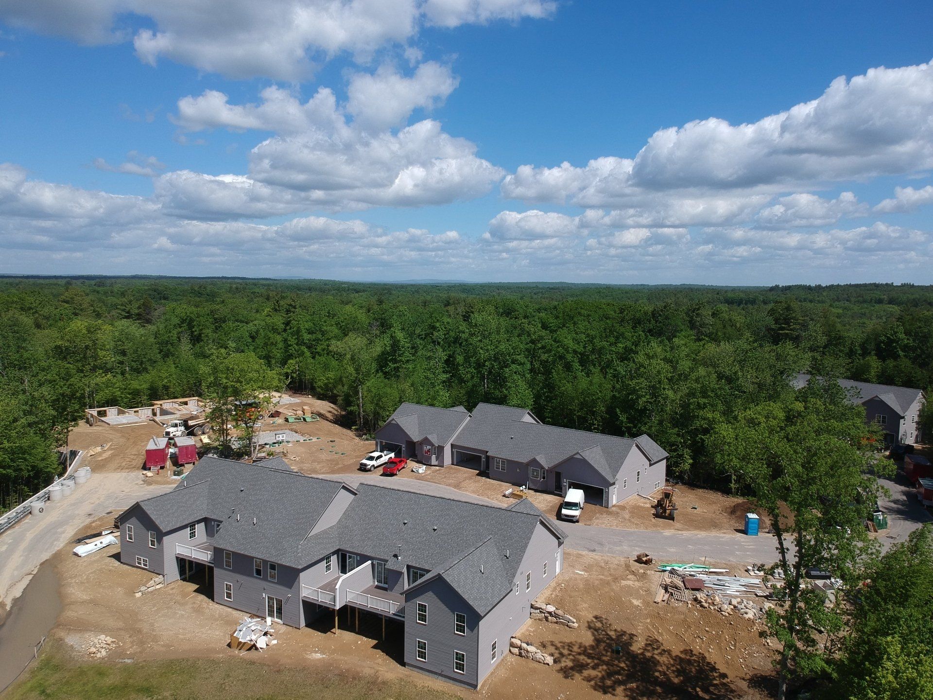 An aerial view of a house under construction in the middle of a forest.
