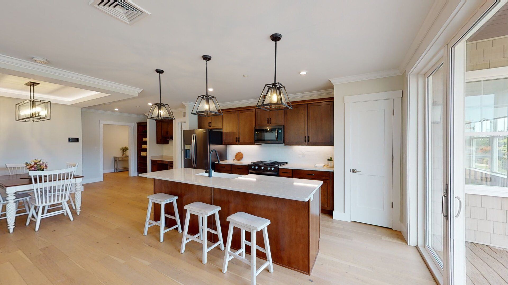 A kitchen with a large island and white stools