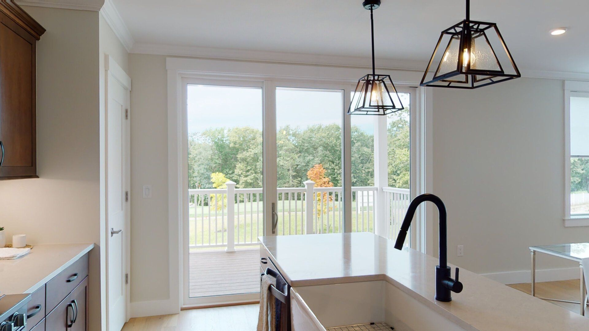 A kitchen with a sink and sliding glass doors leading to a deck.