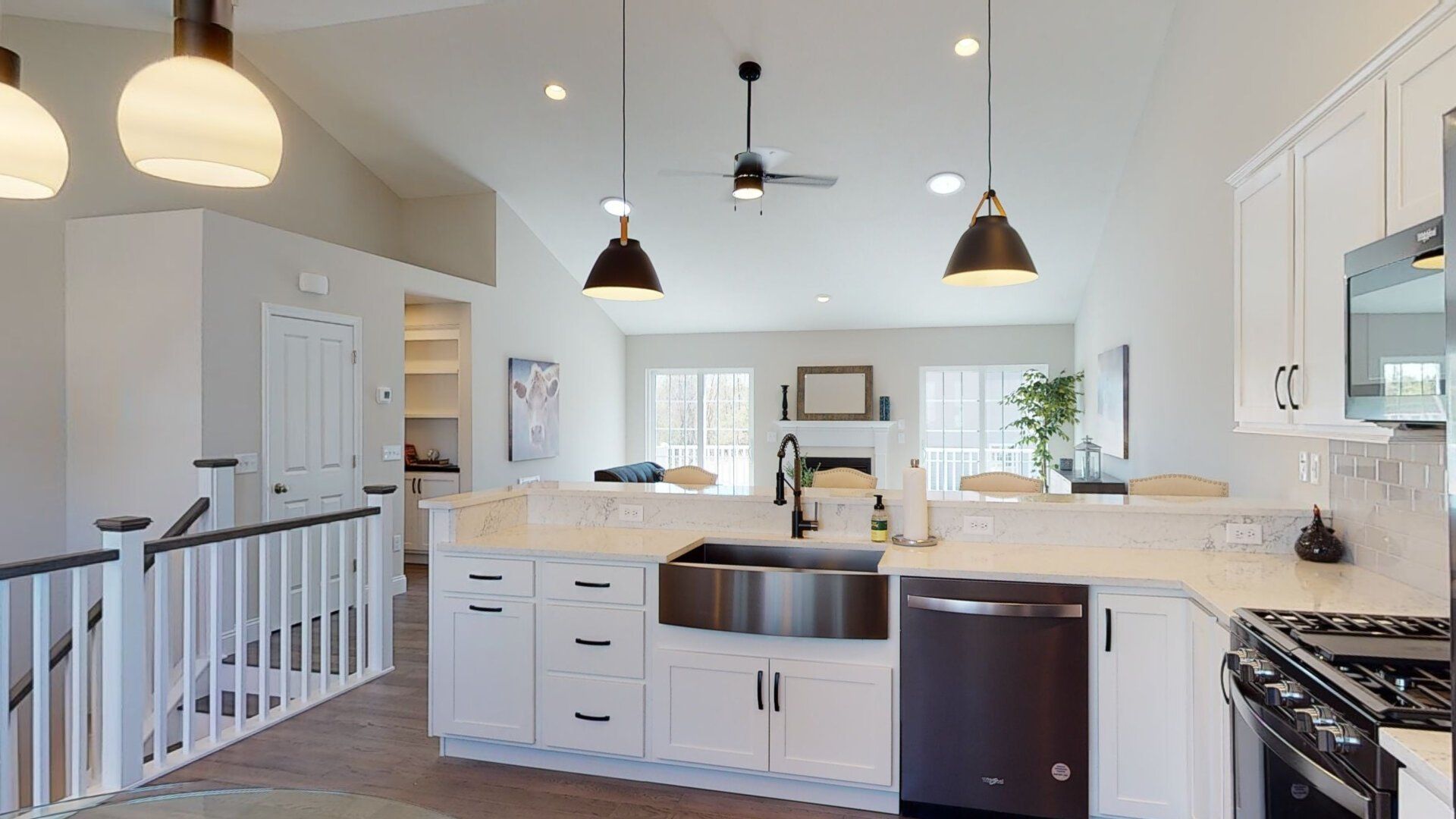 A kitchen with white cabinets , stainless steel appliances , a sink and a stove.