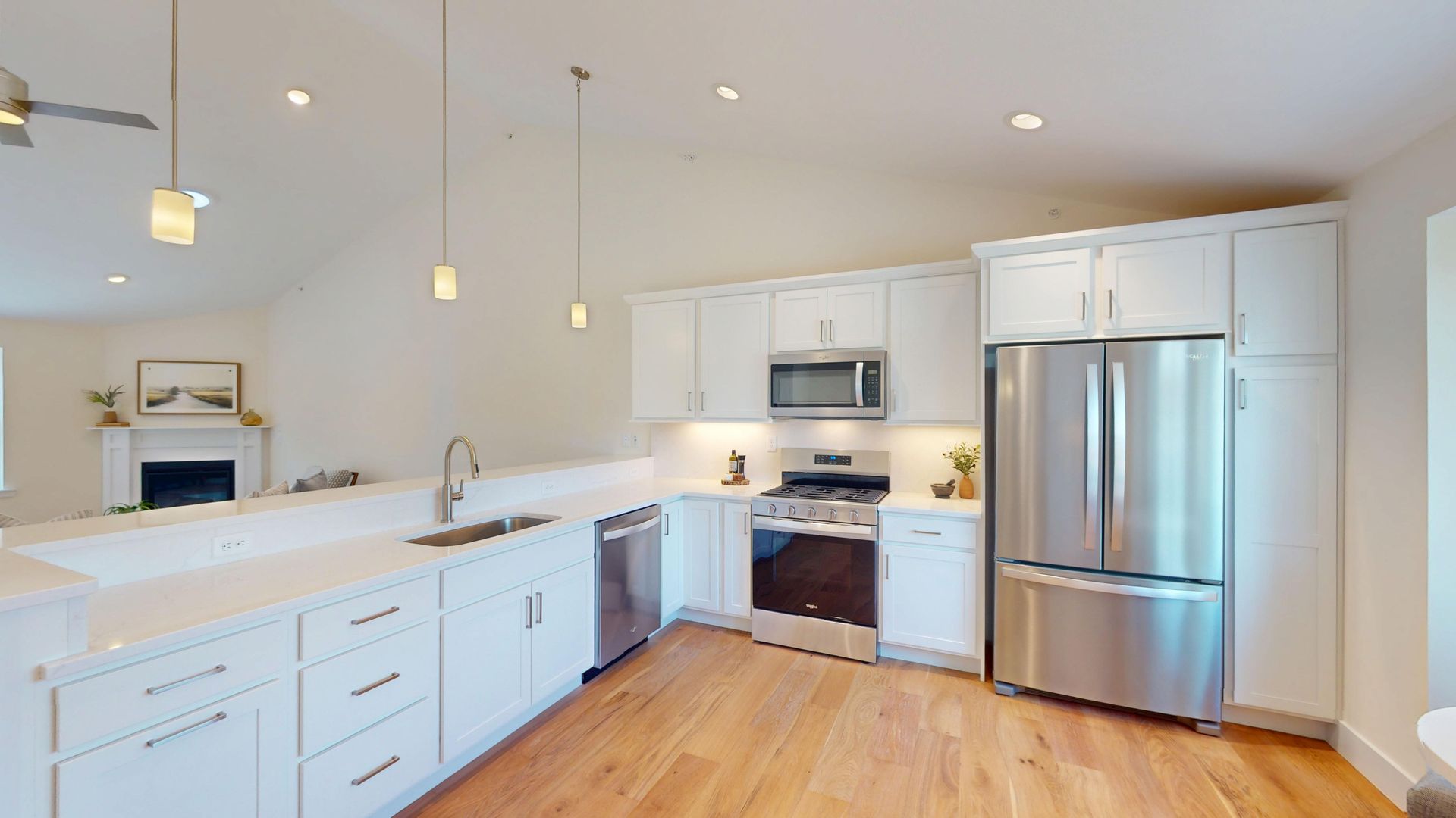 A kitchen with white cabinets and a black refrigerator