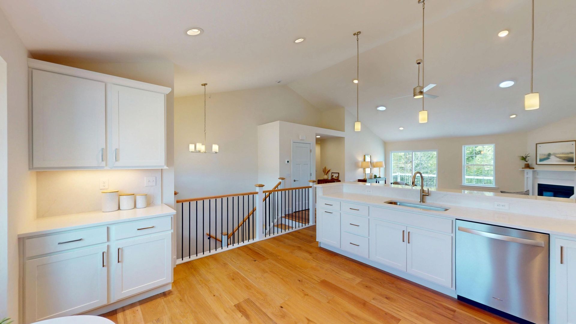 A kitchen with a bar and stools and a dining room in the background.