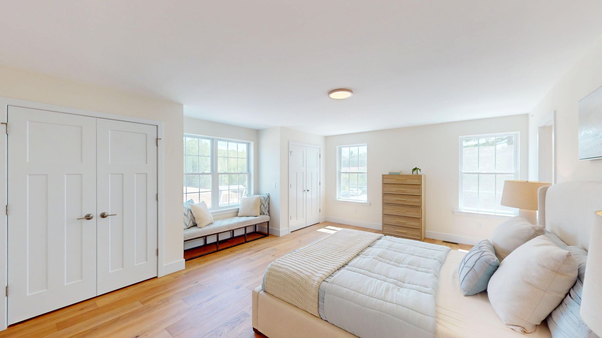 A bedroom with a large bed and a ceiling fan.