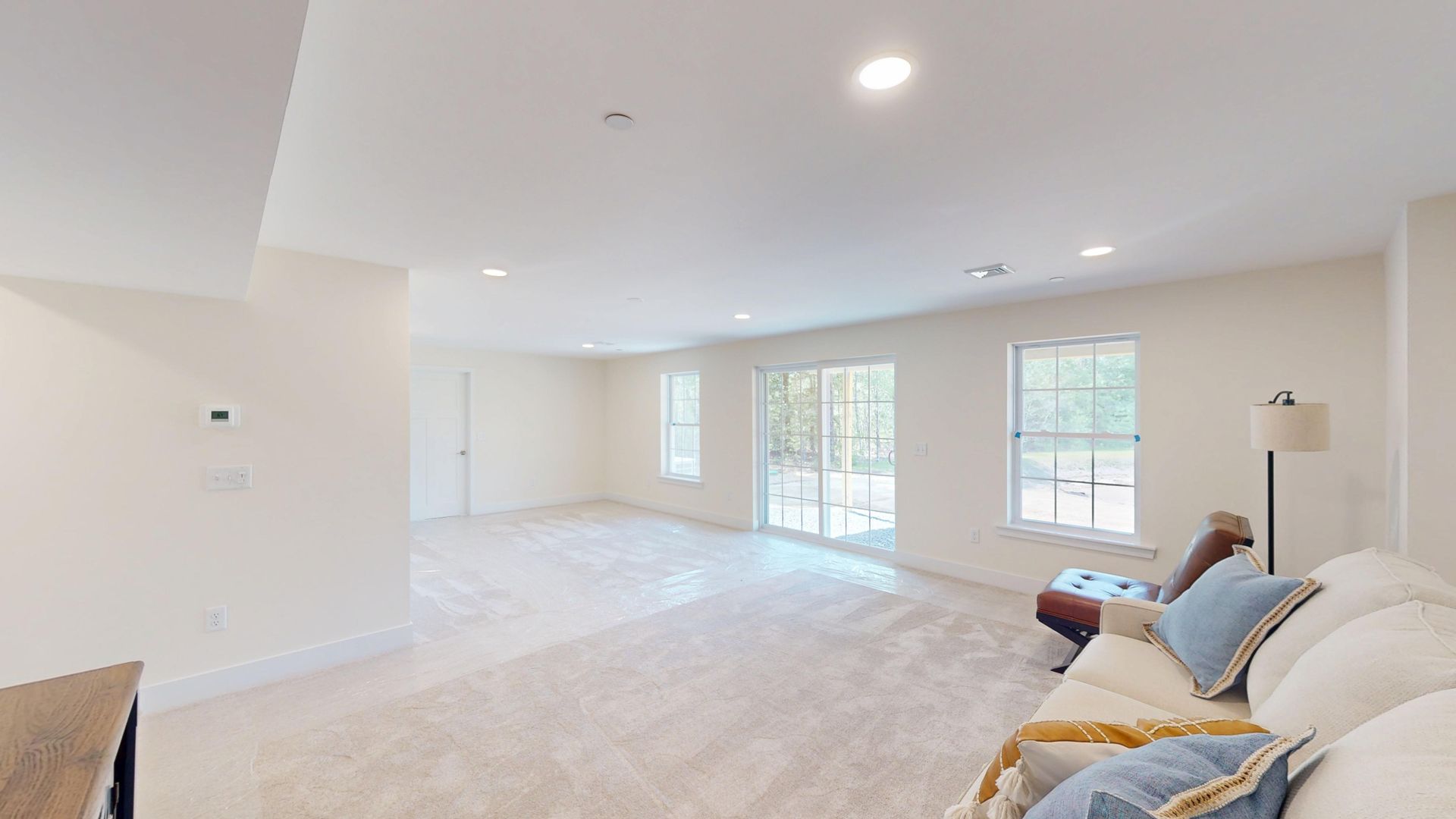 A finished basement room with a red couch and a coffee table