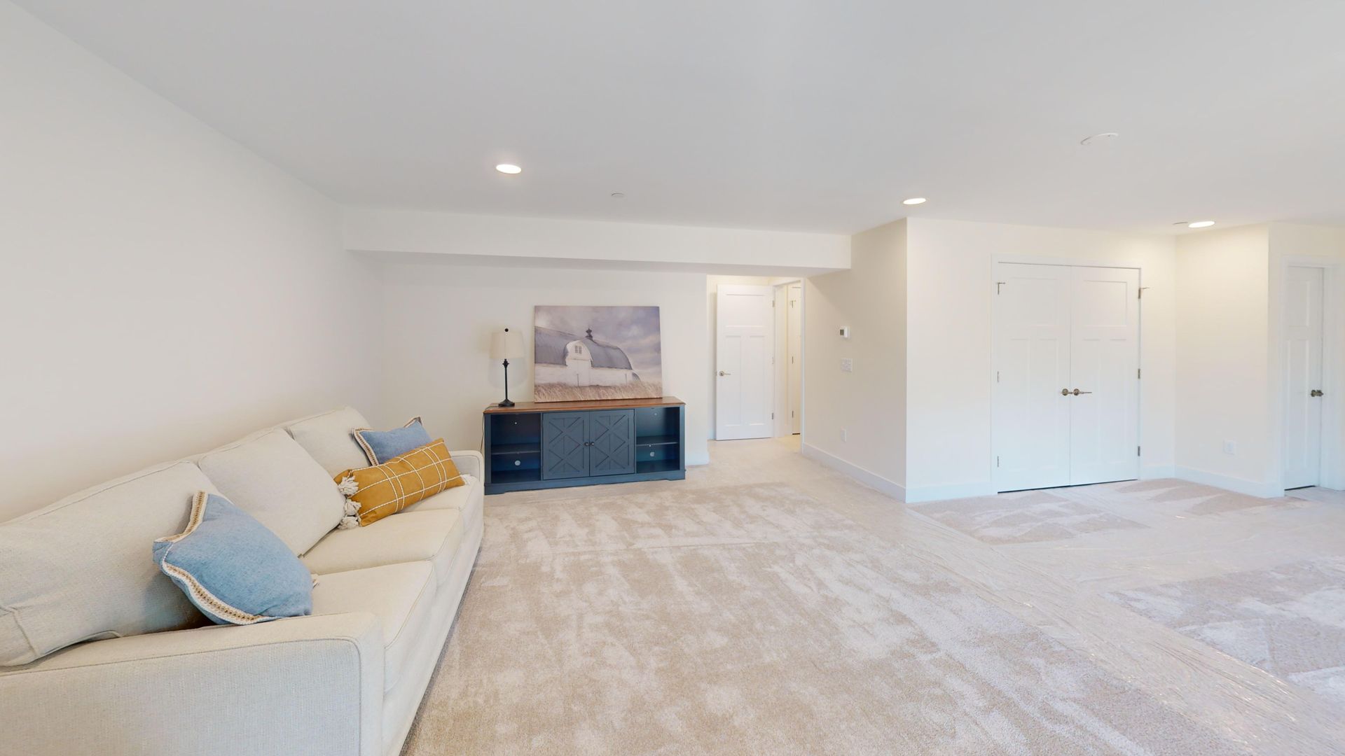 A living room with a couch , chairs , and a ceiling fan.