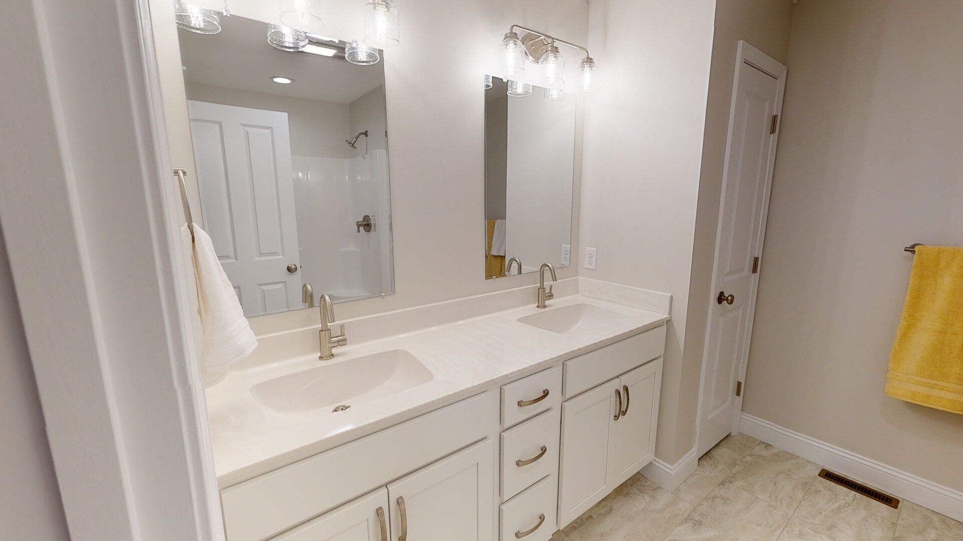 A bathroom with two sinks and a large mirror.