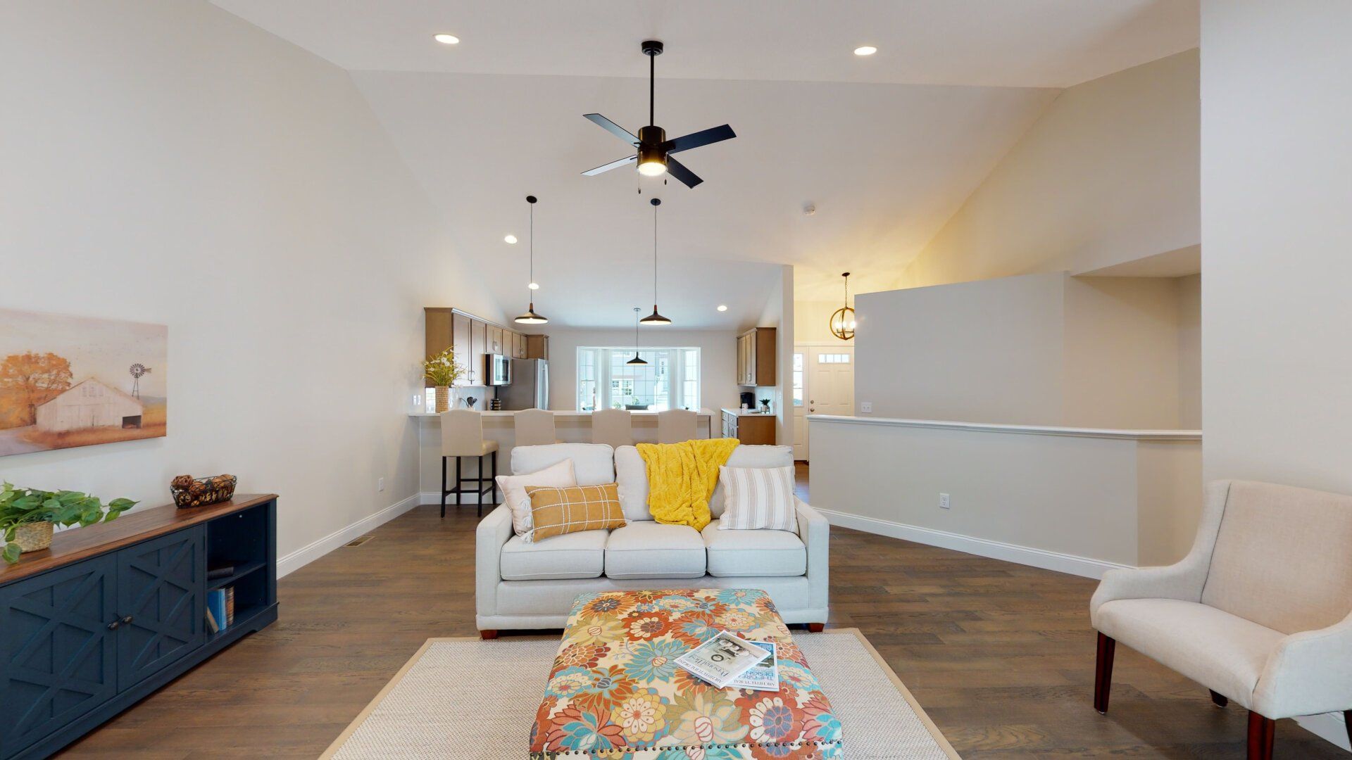 A living room with a couch , chairs , and a ceiling fan.