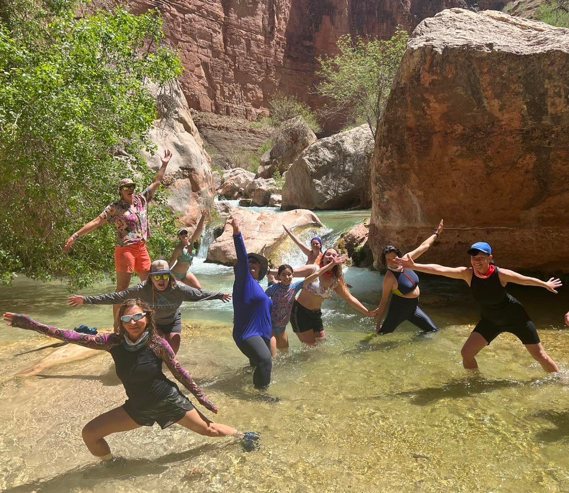 A group of people are posing for a picture in the water