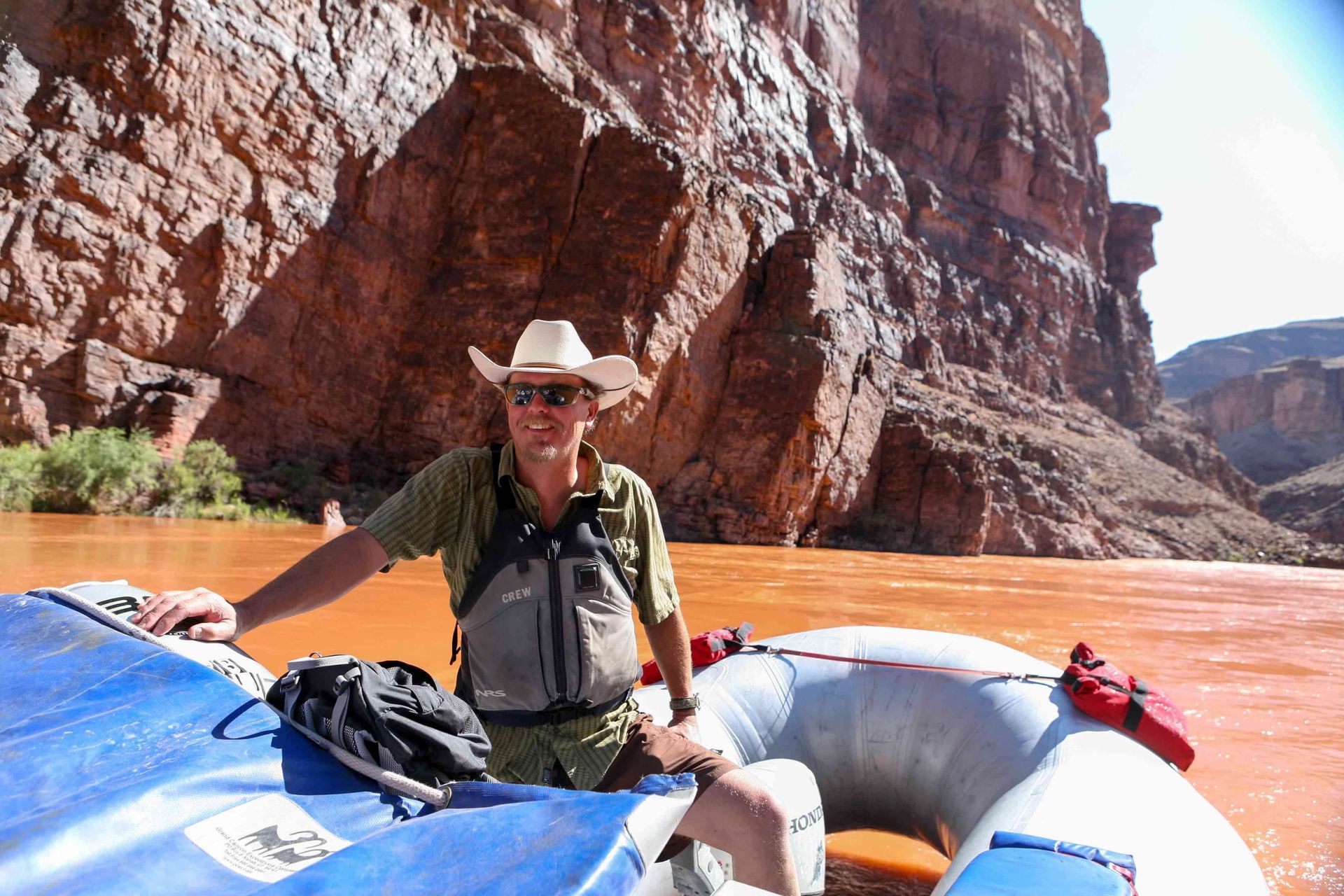 A man with a backpack is sitting on a rock.