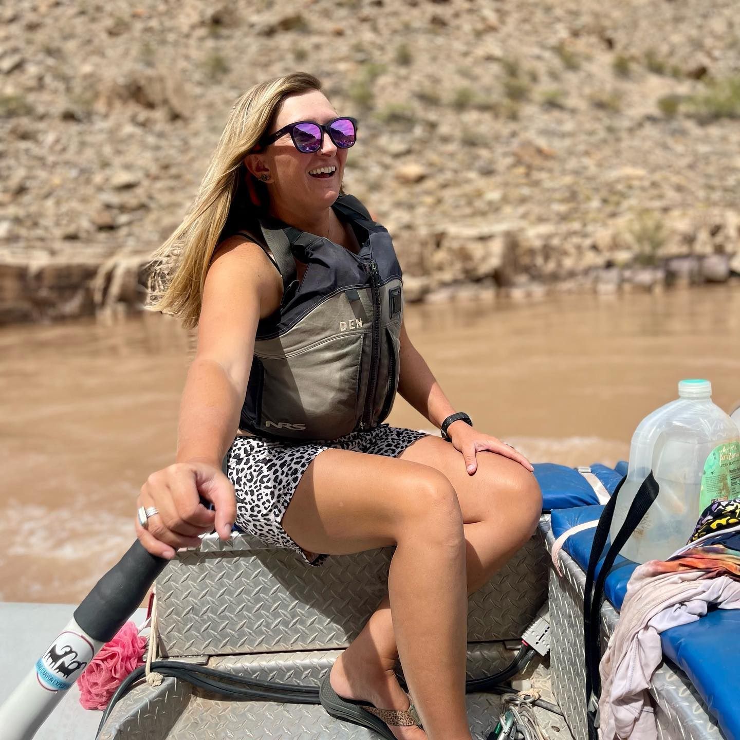 A woman wearing a hat and sunglasses smiles for the camera