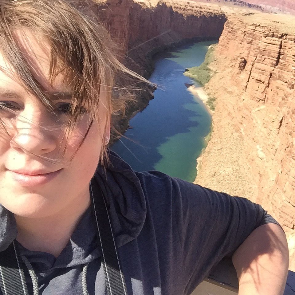 A woman taking a selfie with a river in the background