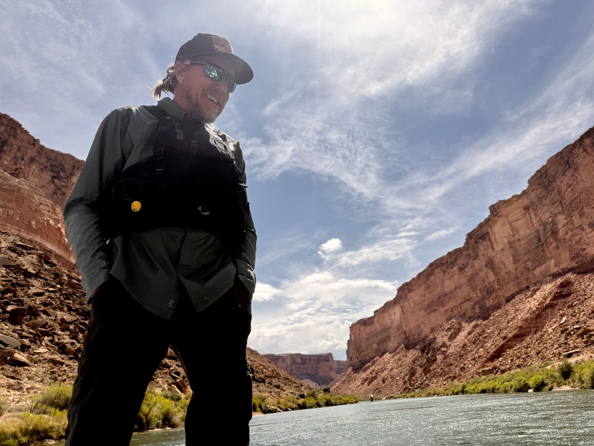 A man wearing a hat and sunglasses is sitting in a raft