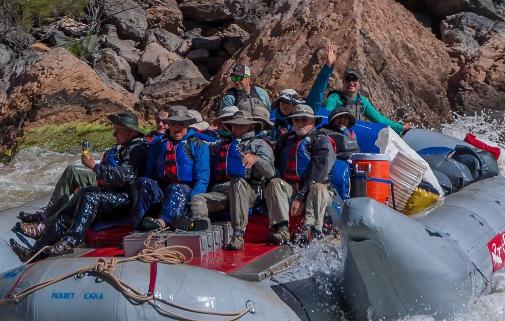 A group of people in life jackets are swimming in a river