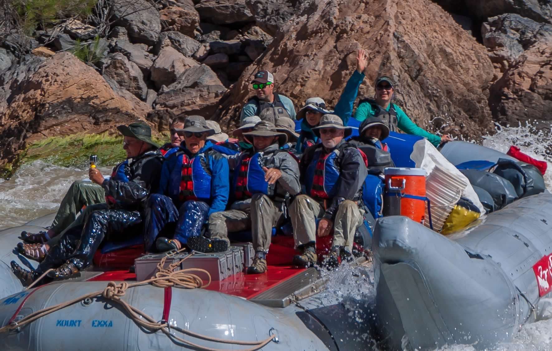 A group of people in life jackets are swimming in a river