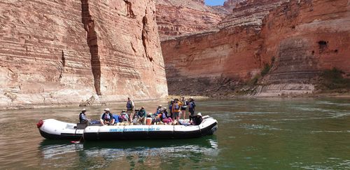 A group of people are on a boat that says ' nv ' on the side