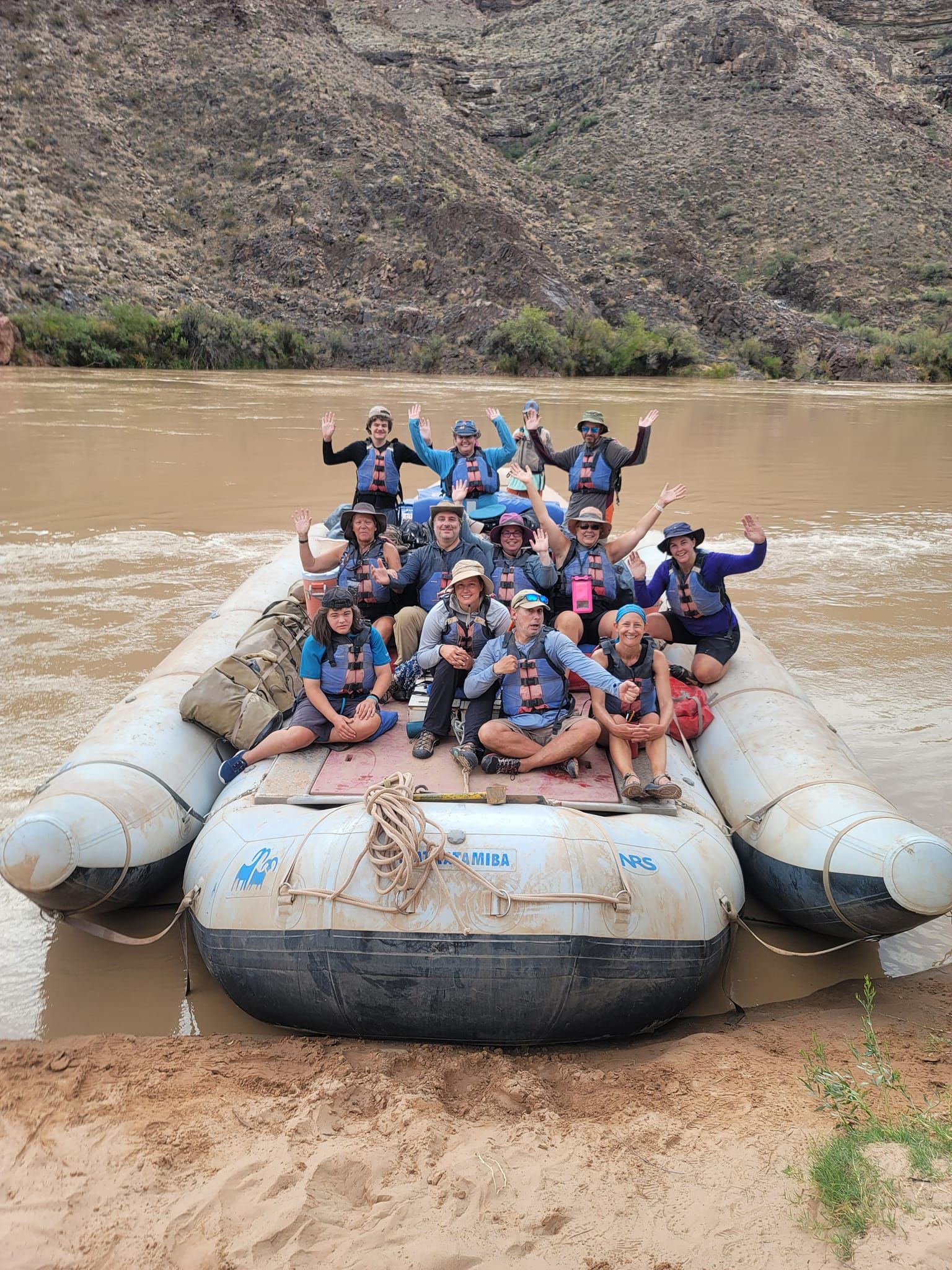 A group of people are sitting on top of a raft in the water.