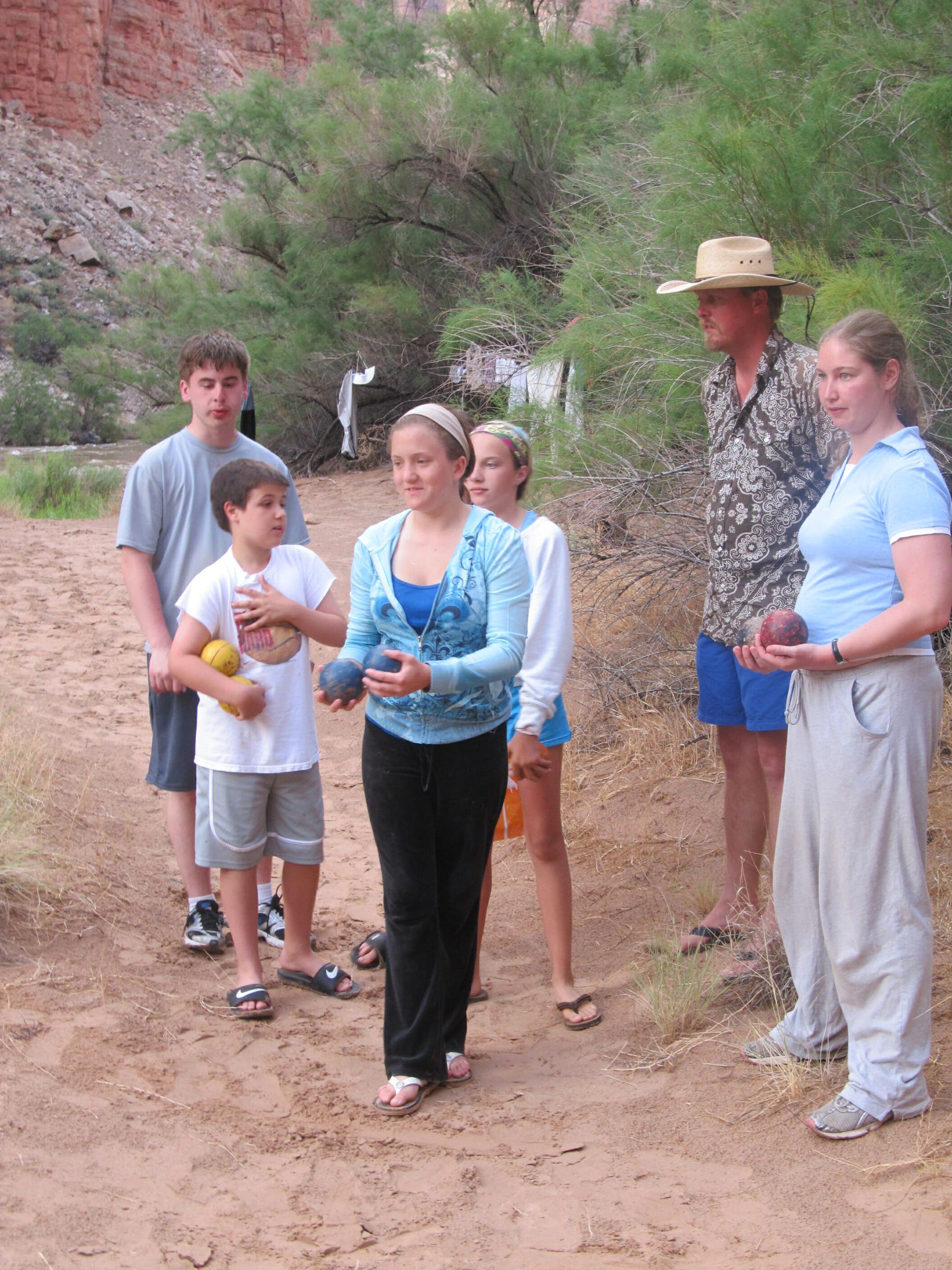 A group of people standing on a dirt road