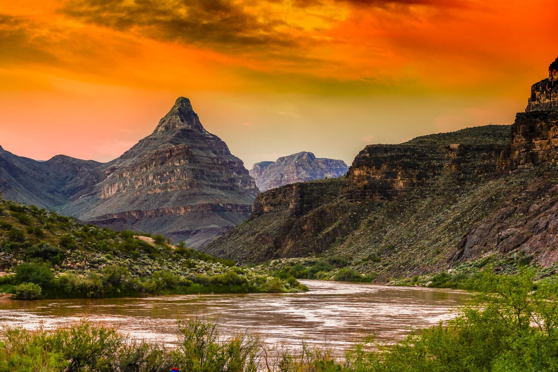 A river flowing through a canyon with mountains in the background