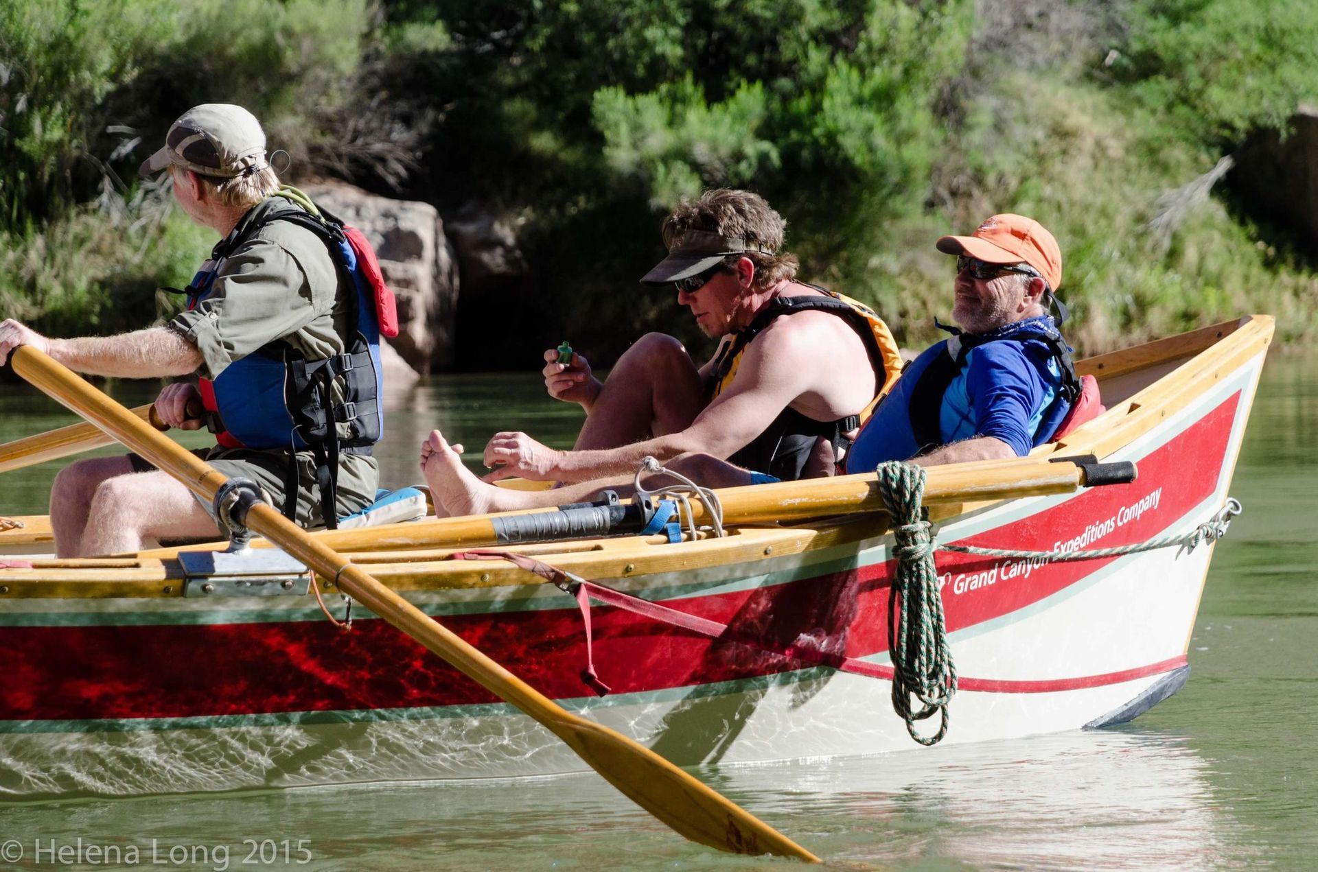 A group of men are rowing a boat on a river