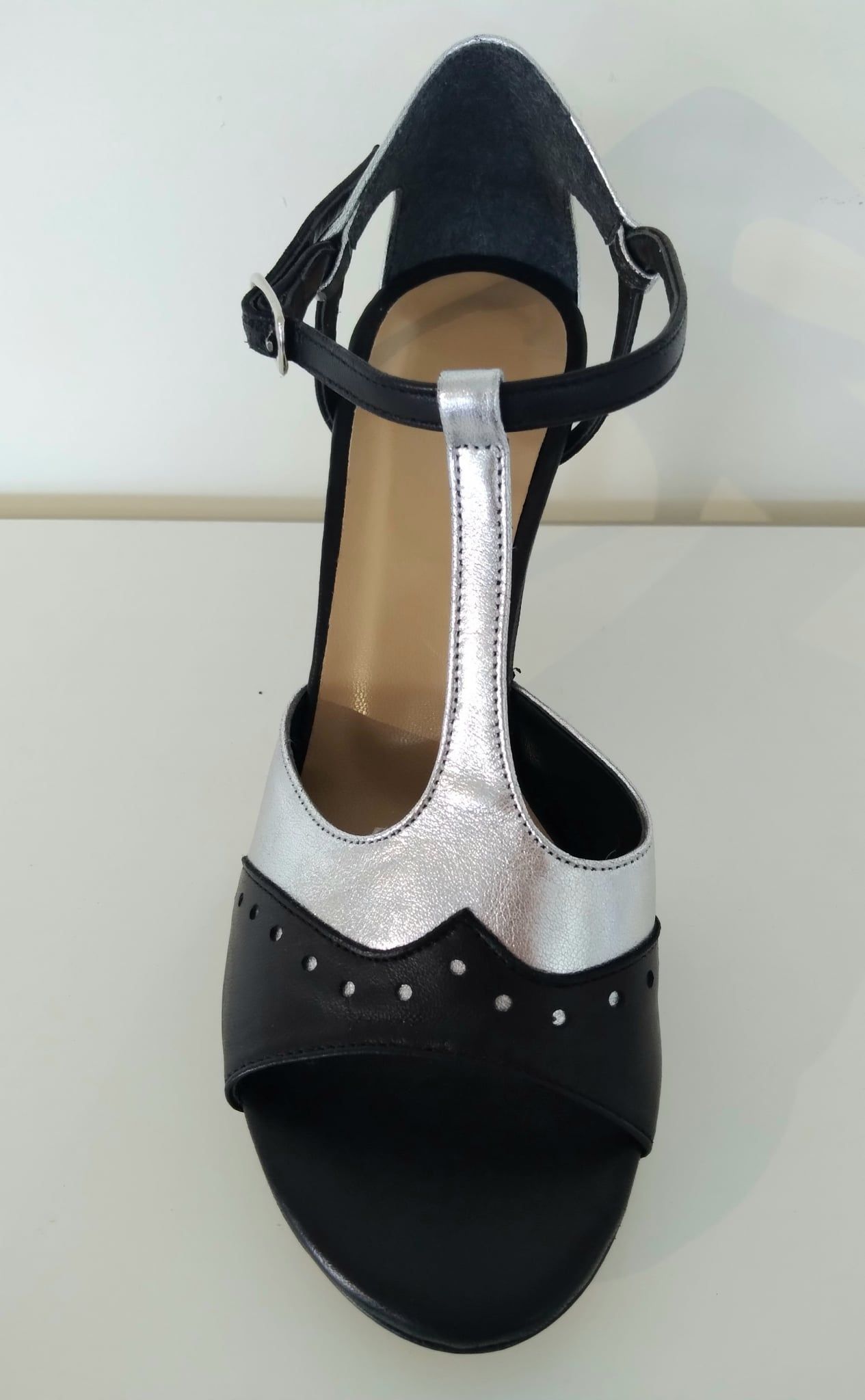 Black and silver heeled sandal with ankle strap and t-strap.
