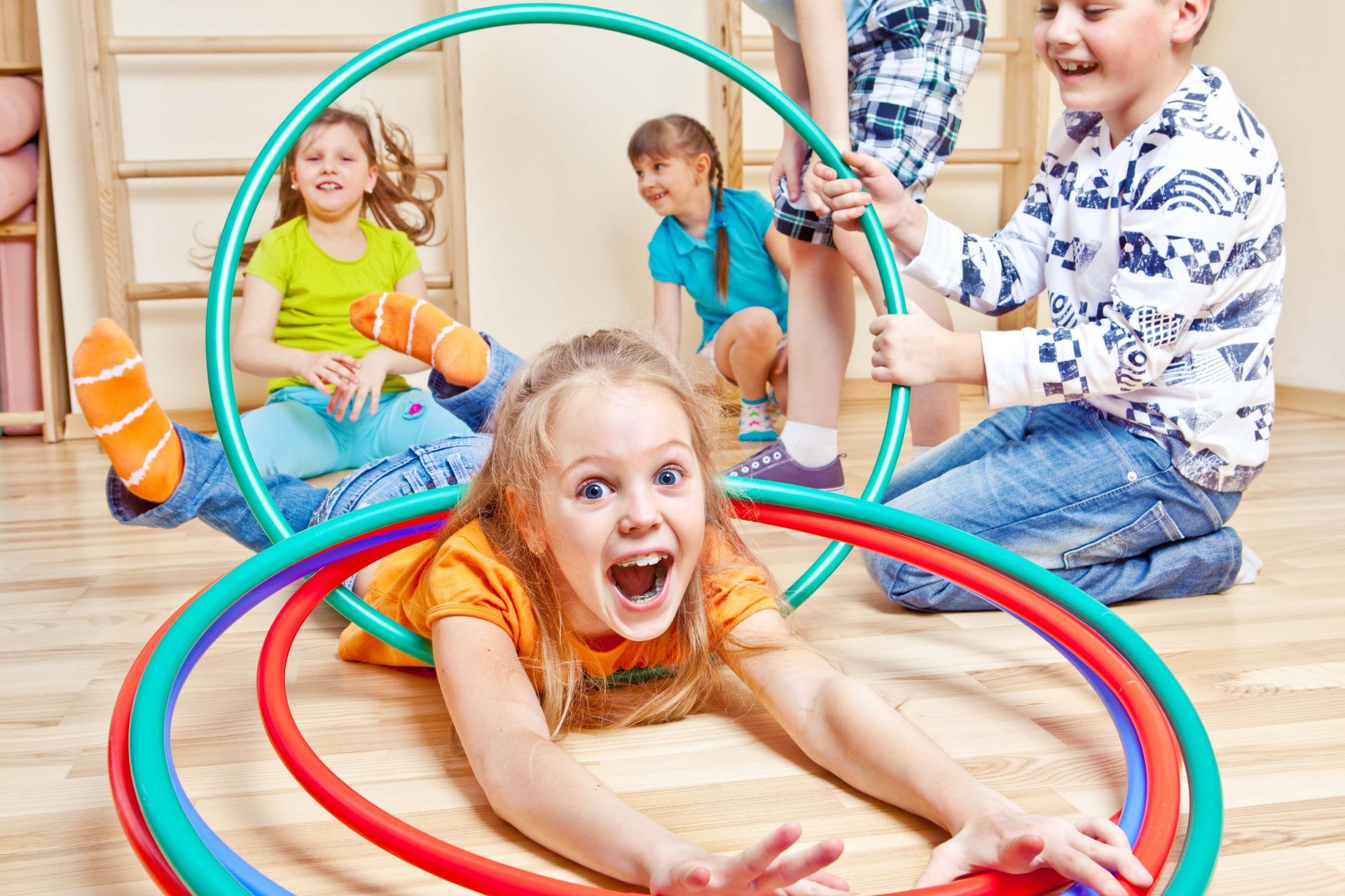 a group of children are playing with hula hoops on the floor