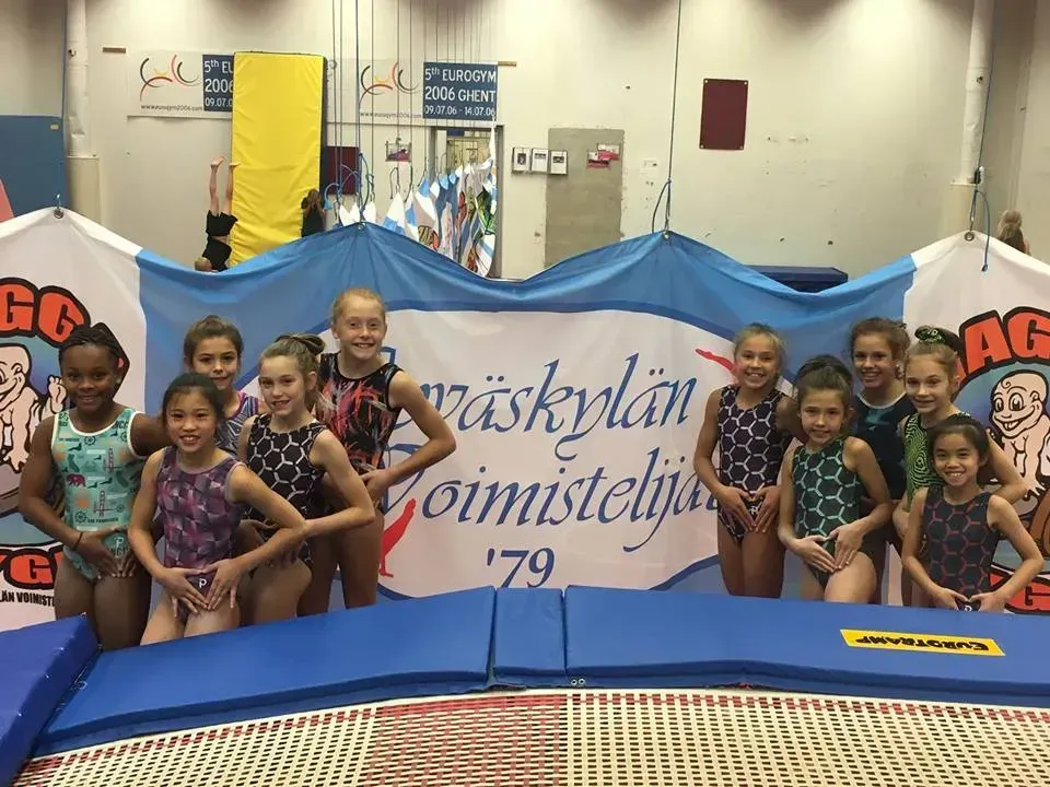 a group of young girls are posing for a picture in front of a sign that says ' vaskyplan ' on it