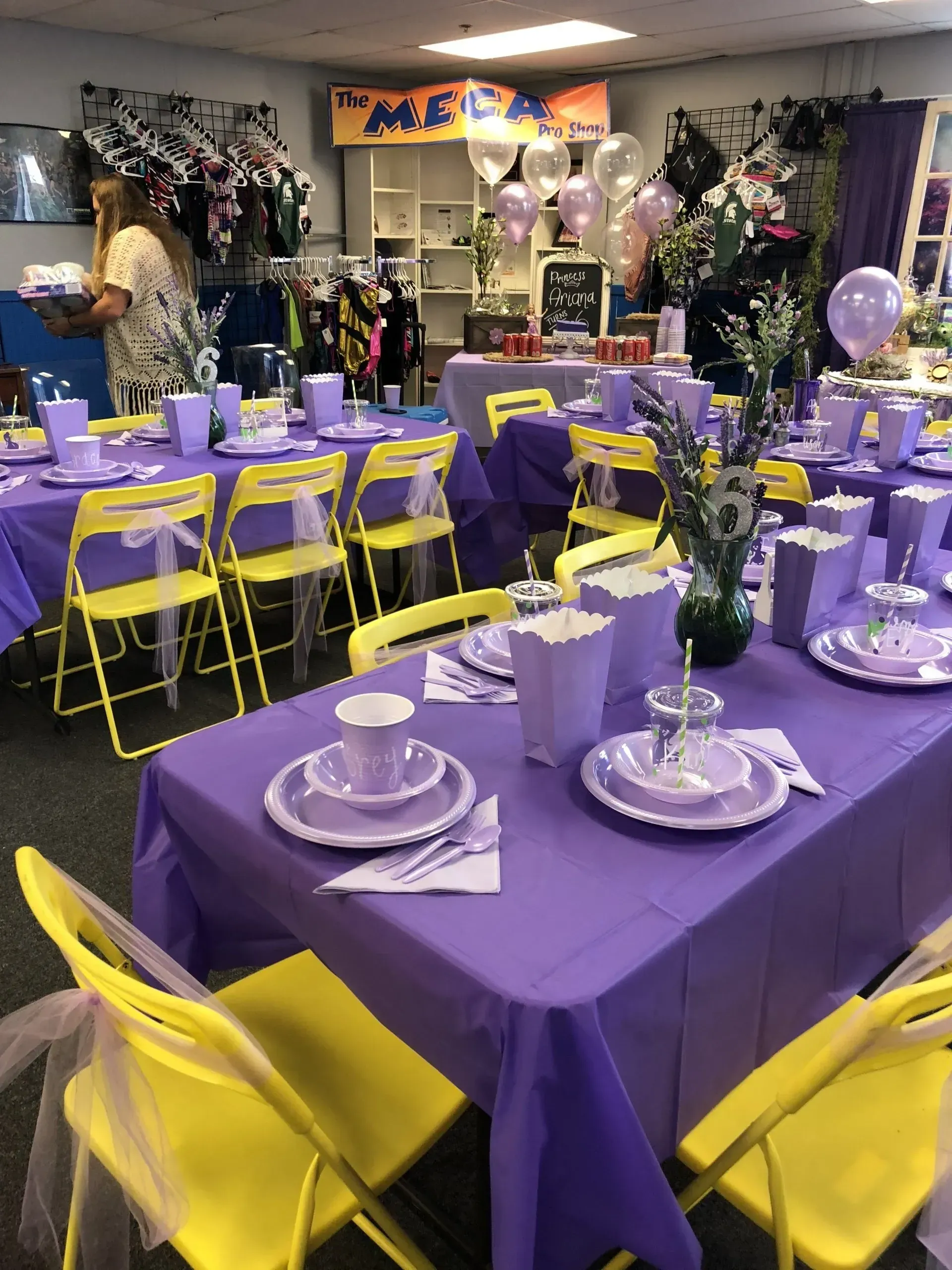 a room with purple tables and yellow chairs