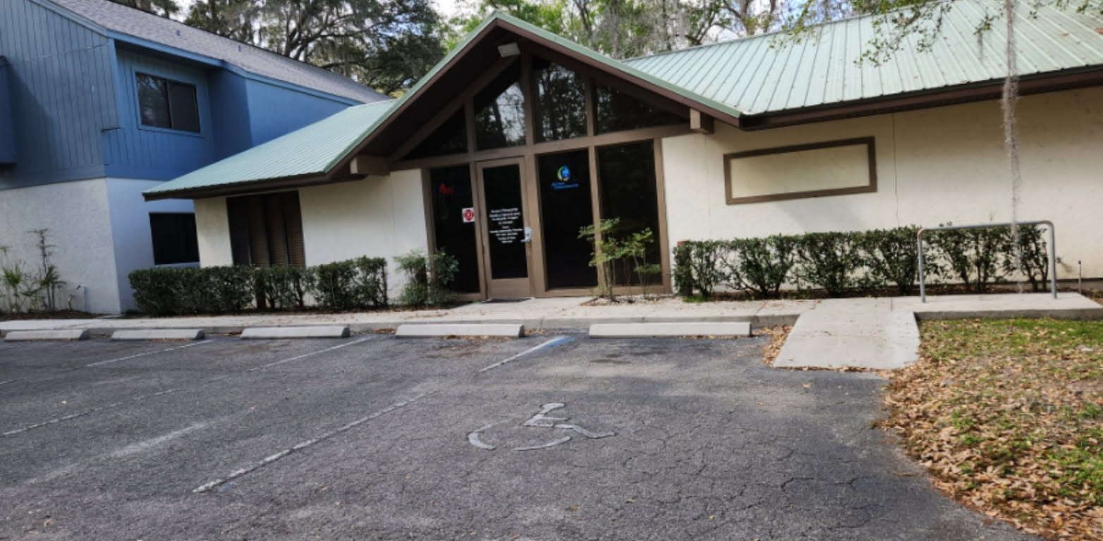 A motorcycle is parked in front of a building with the number 13 on it