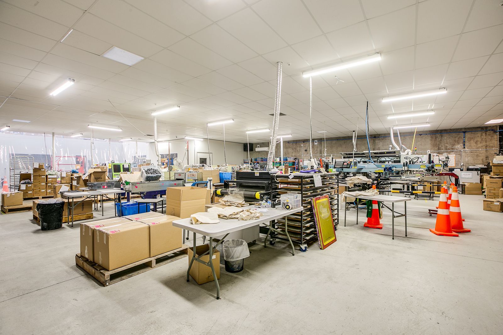 A large warehouse filled with lots of tables and boxes.