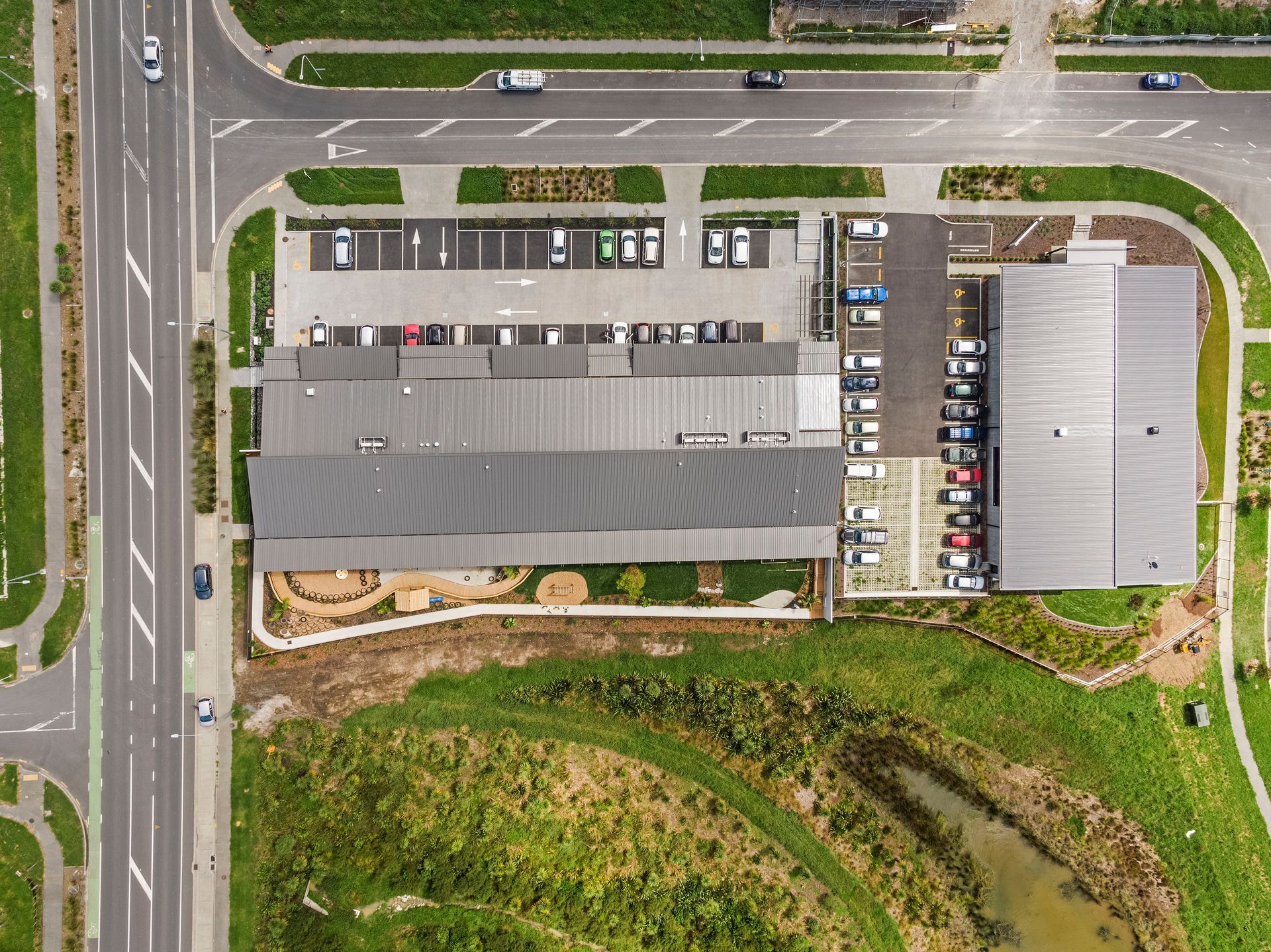 An aerial view of a large building with a parking lot in front of it.