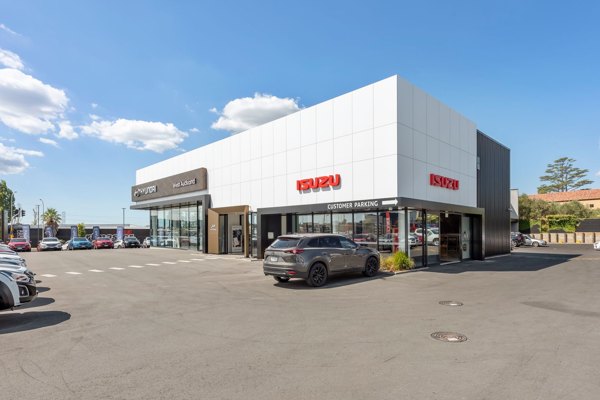 A car is parked in front of a car dealership.