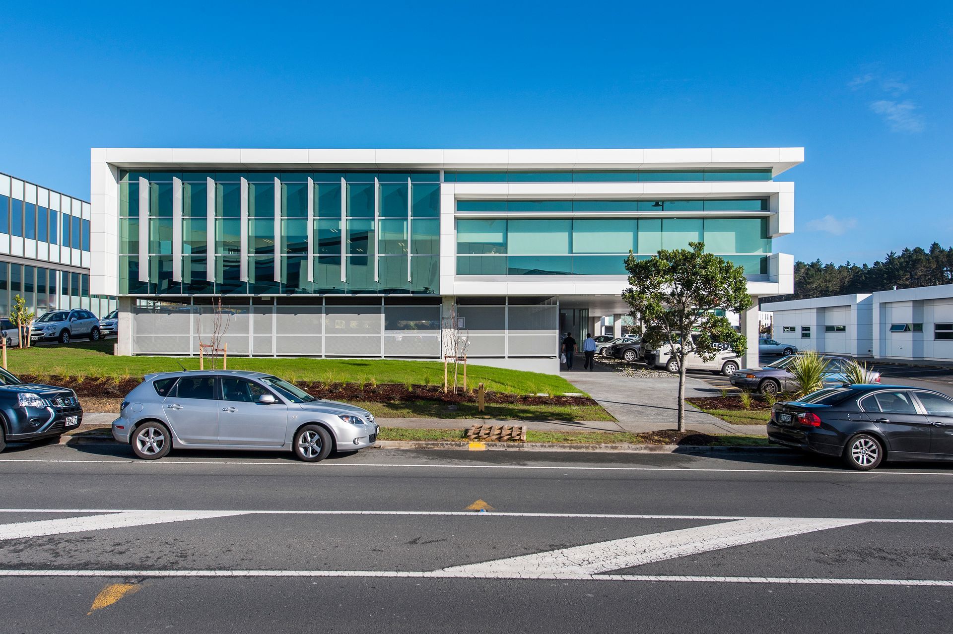 A building with a lot of windows and cars parked in front of it.