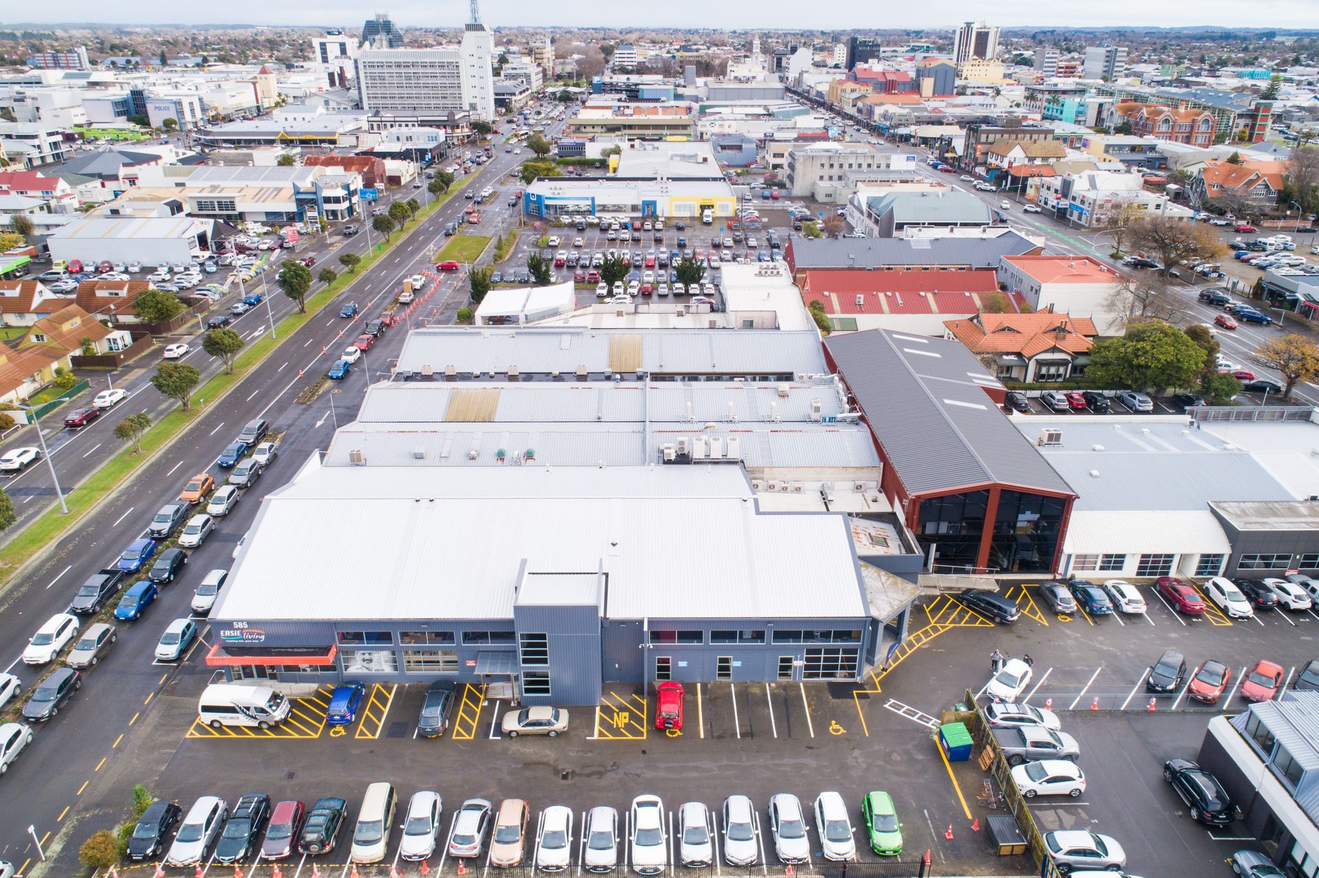 An aerial view of a city with a lot of cars parked in front of buildings.