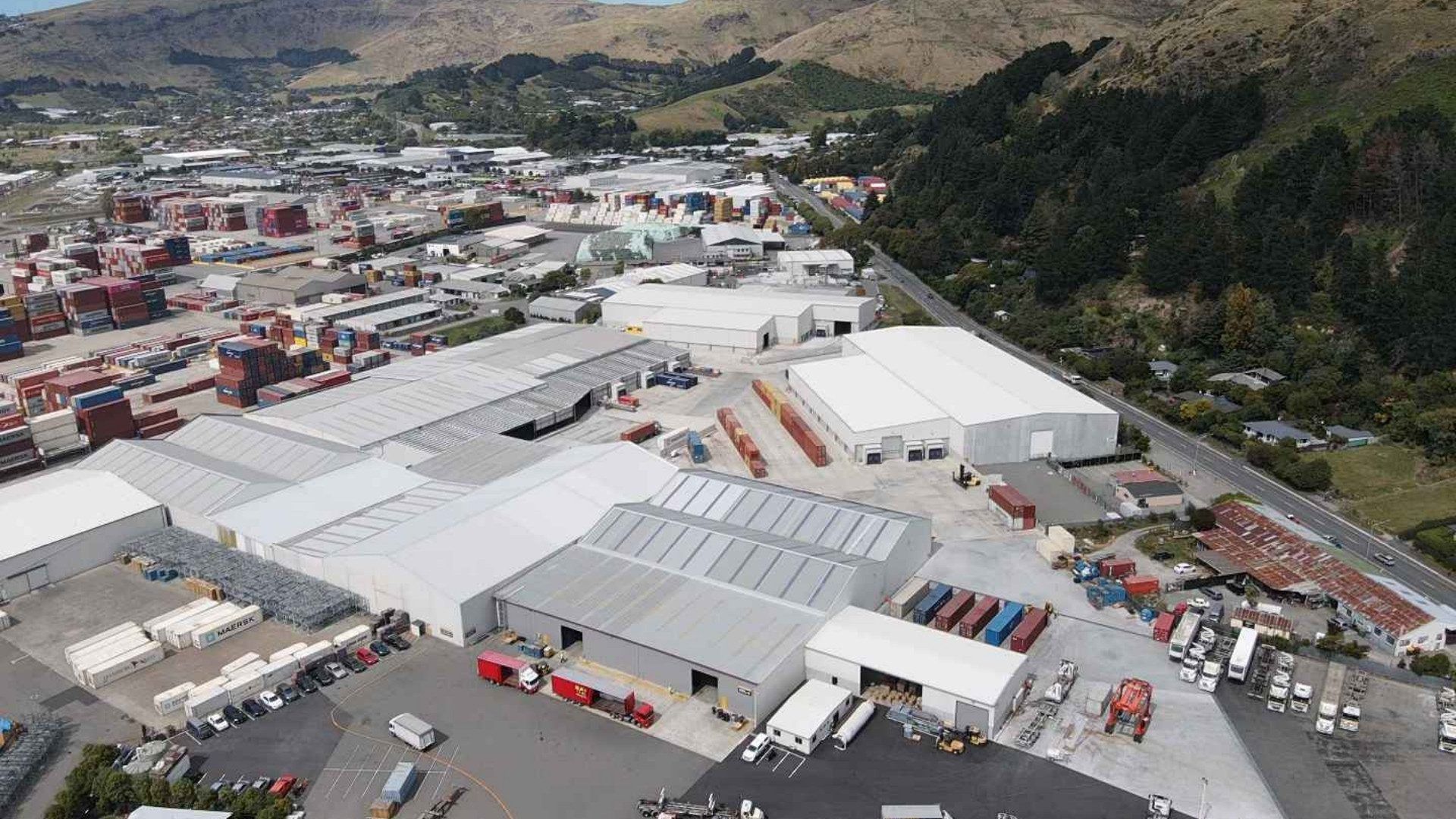 An aerial view of a large industrial area surrounded by mountains.