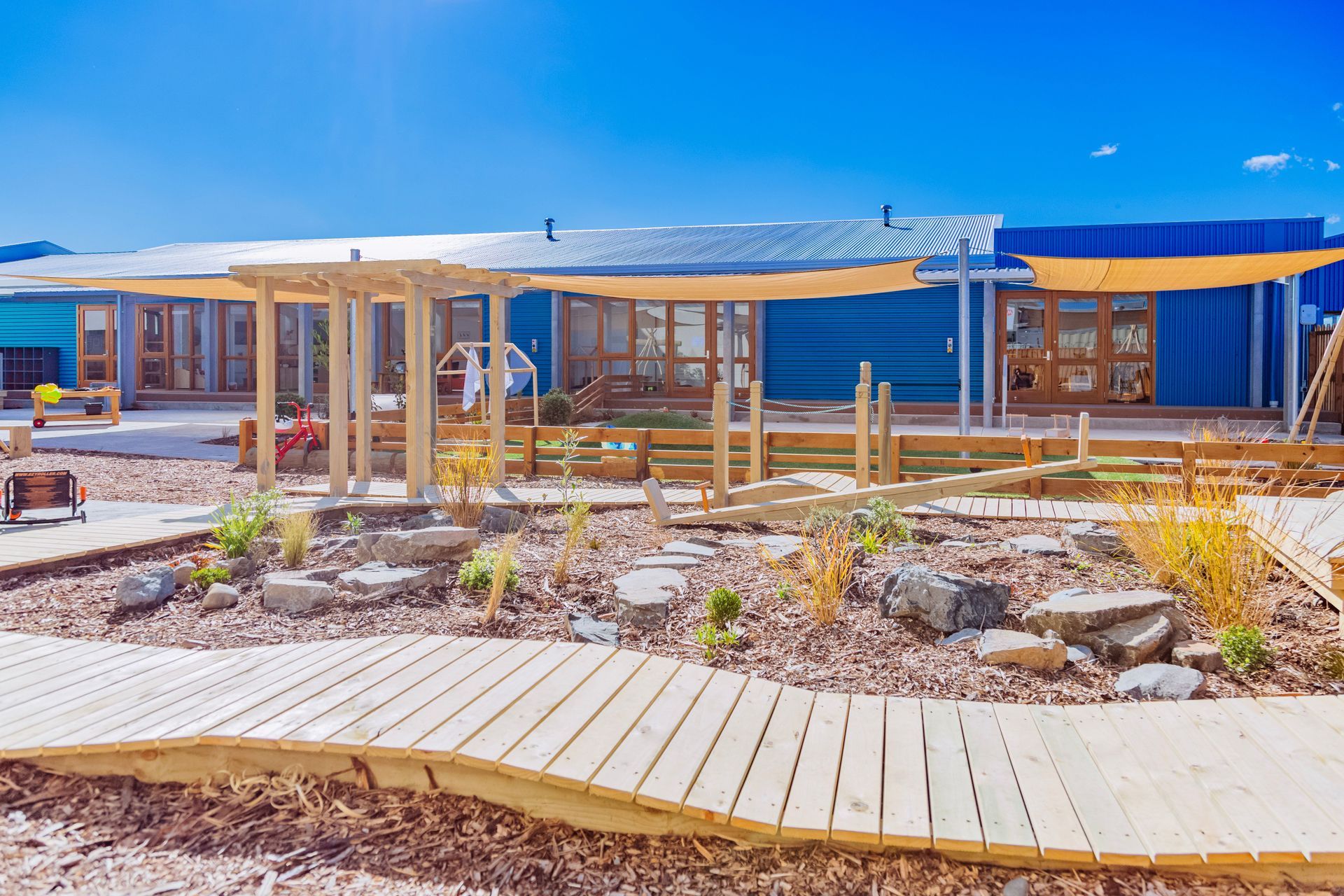 A large blue building with a wooden walkway leading to it.