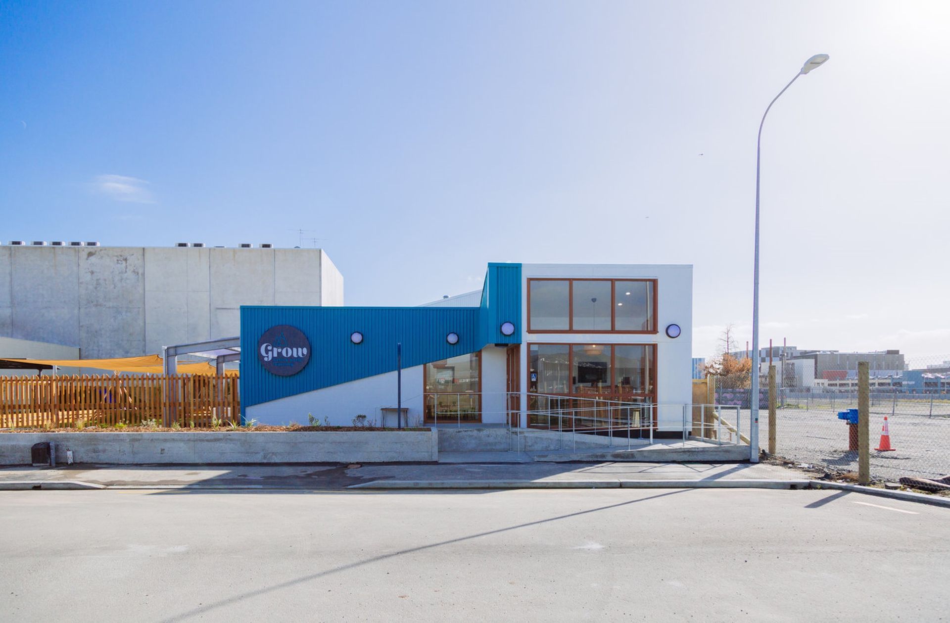 A blue and white building is sitting on the side of a road.