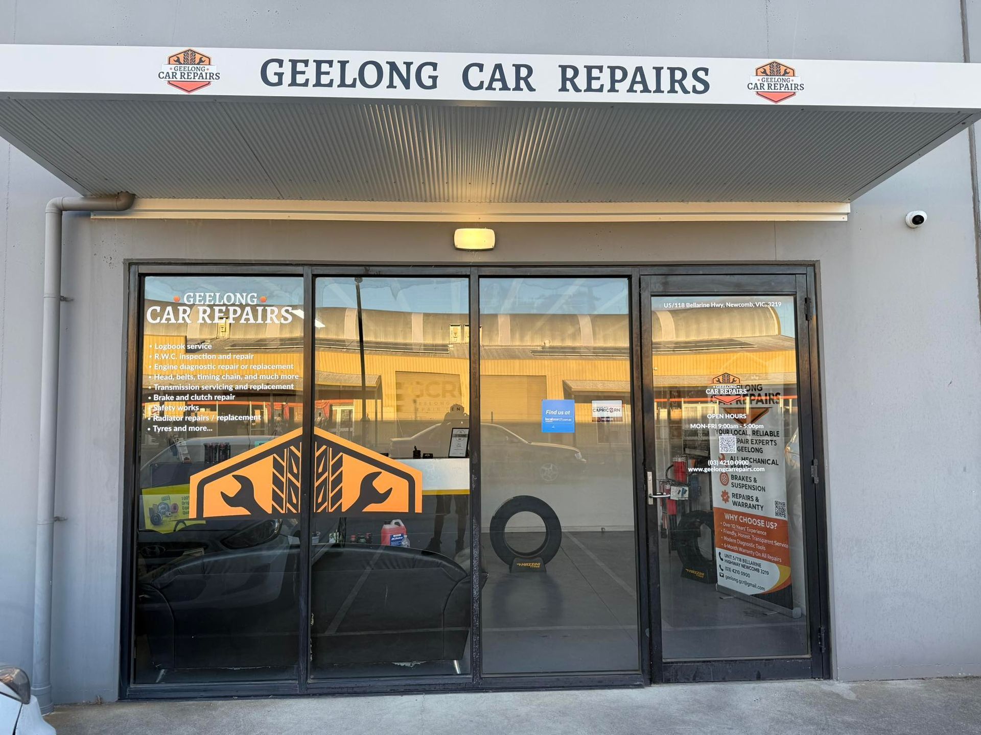 A Commercial Warehouse Exterior with Two Parked Cars — Geelong Car Repair Centre in Newcomb, VIC