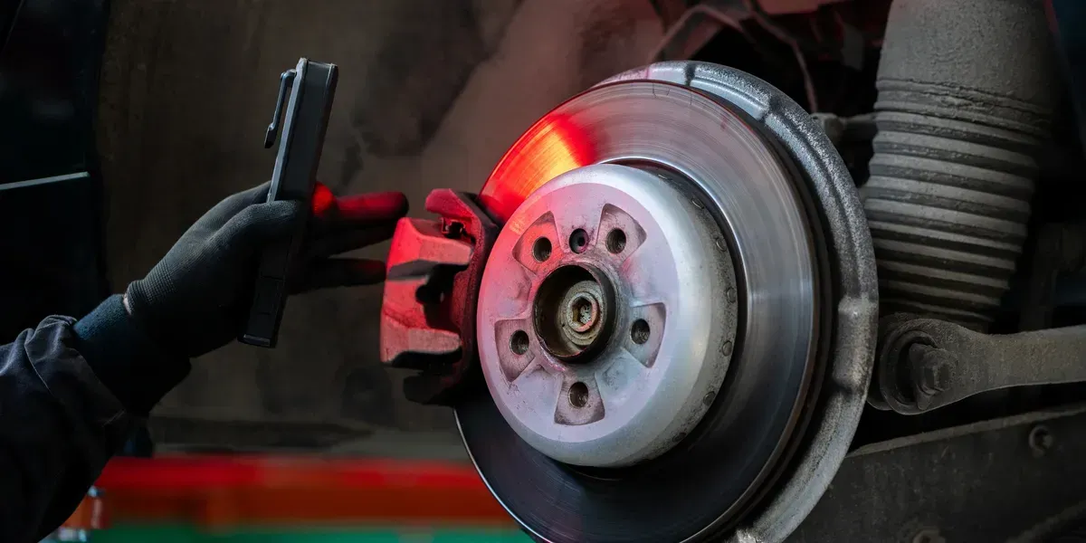 A Mechanic Inspecting a Car Brake Rotor with A Tool — Geelong Car Repair Centre in Newcomb, VIC