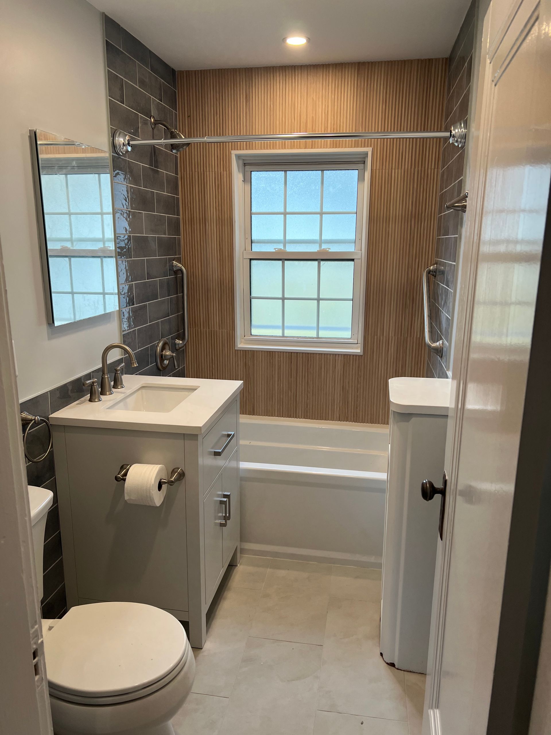 Completed bathroom remodeling project in Arlington, MA, with slate tile and a soaking tub.