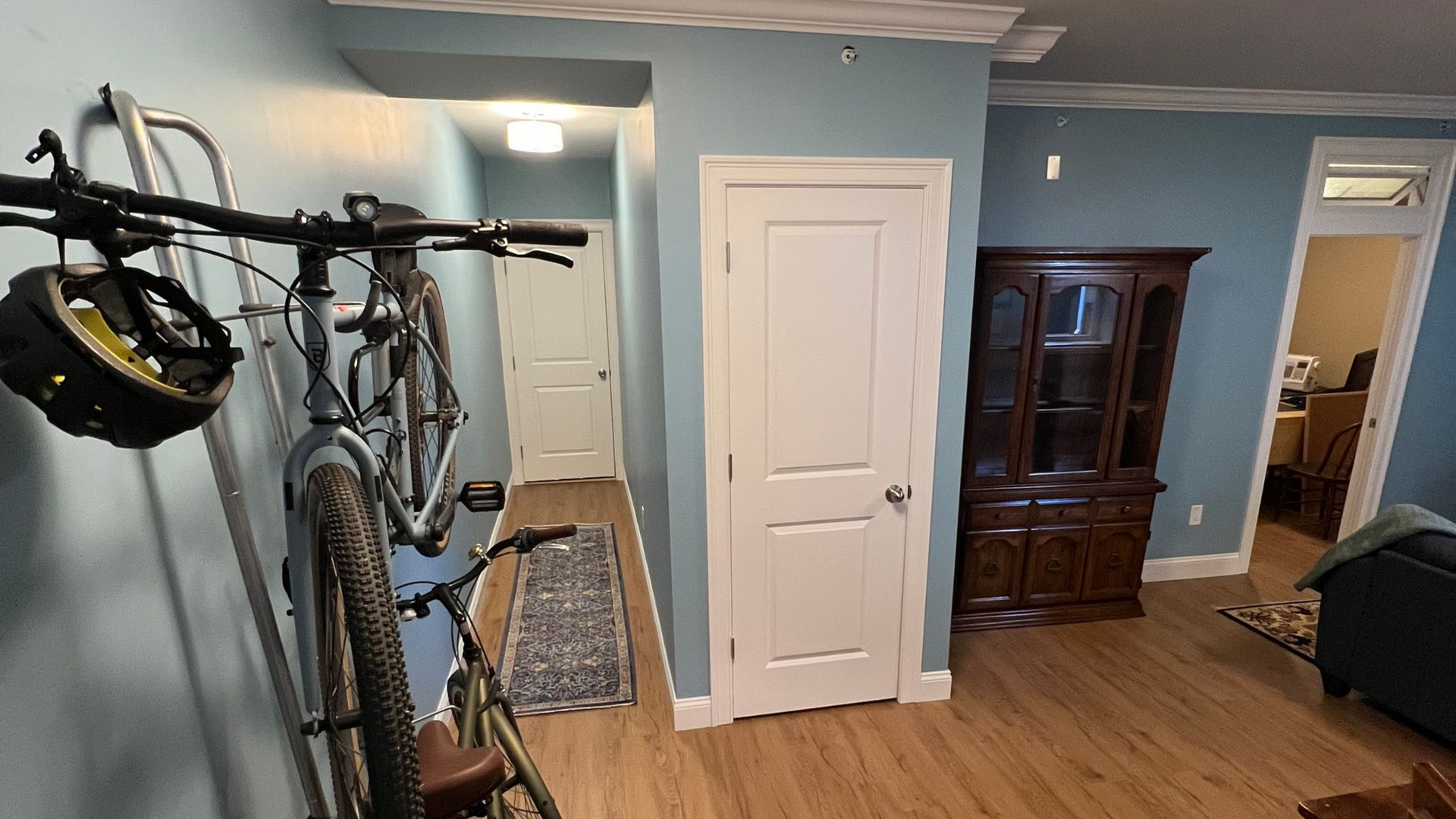 Finished basement hallway with white doors, built-in storage hutch, and bike storage rack