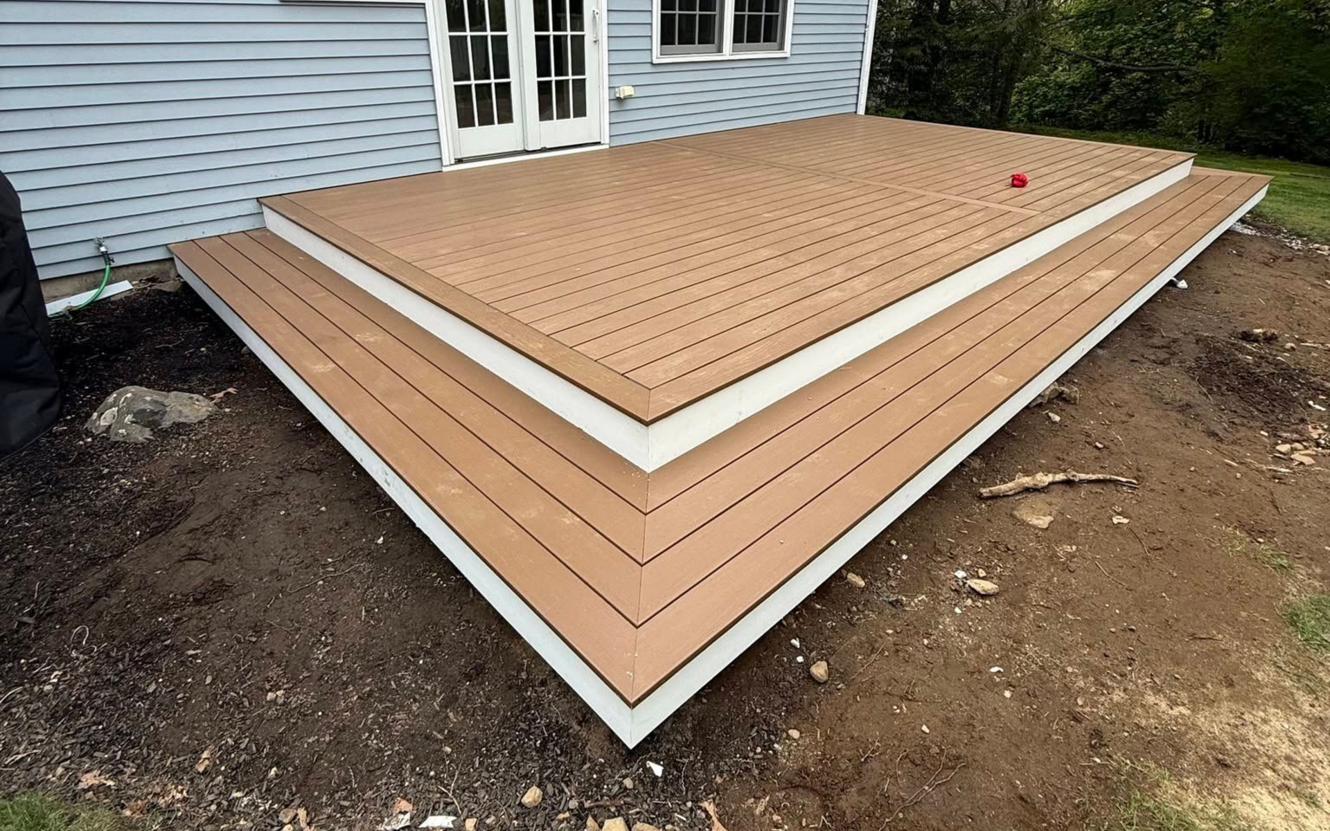 Completed composite deck with wraparound corner steps and white PVC fascia by A-Z Finish Carpentry in Marblehead MA