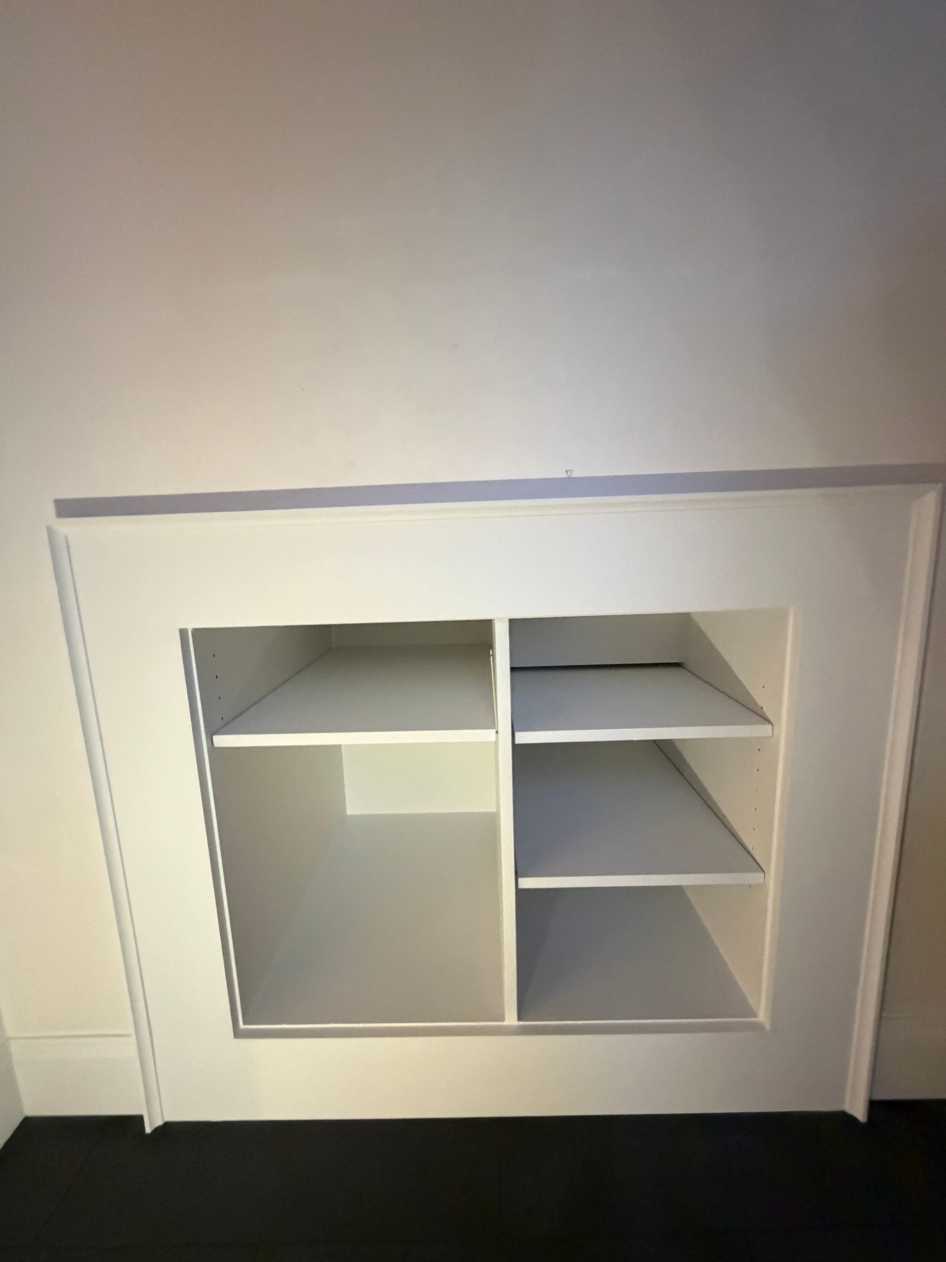 closeup of Custom recessed storage shelving built directly into the mudroom wall during construction