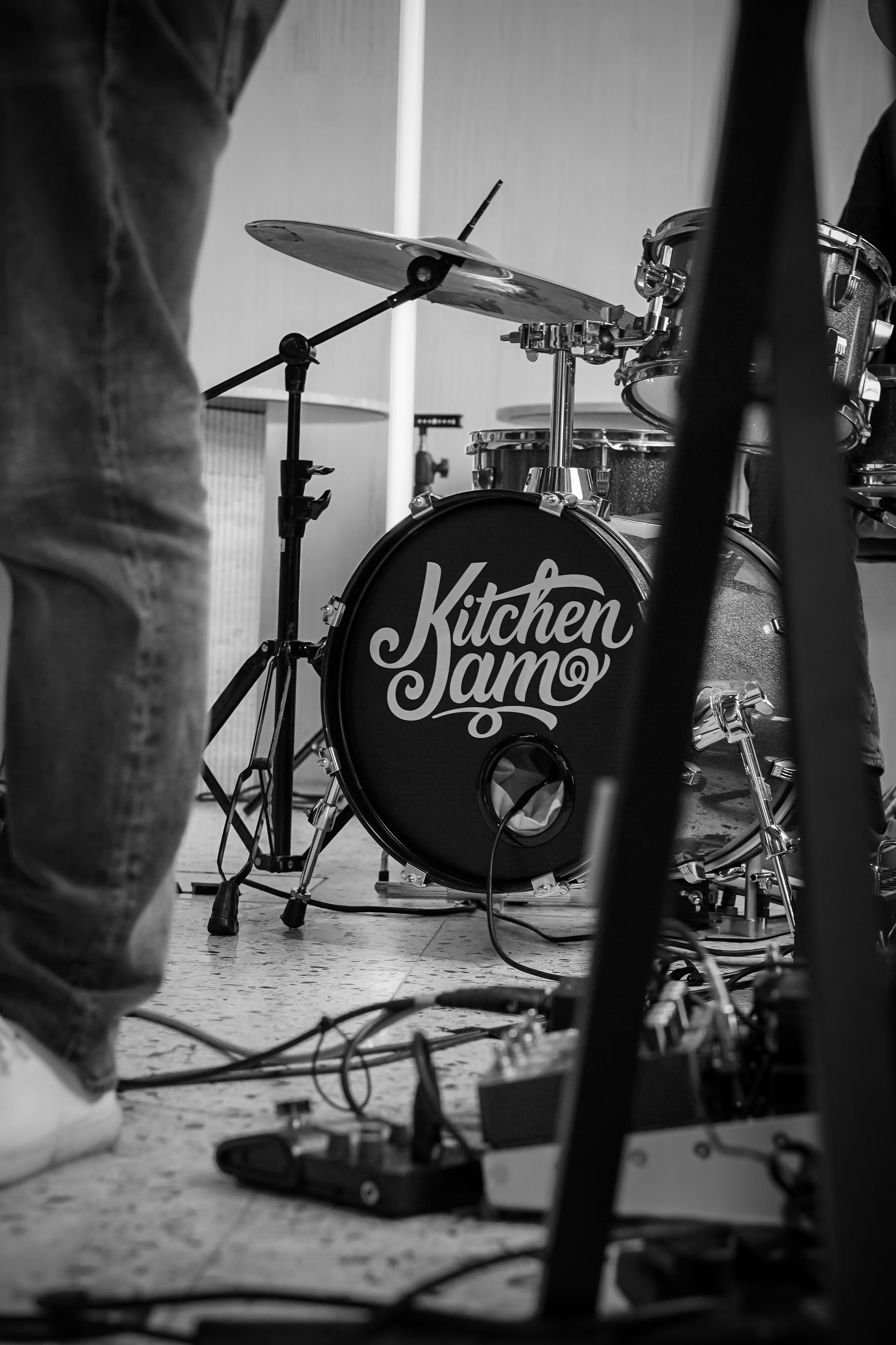 Black-and-white photo of a drum kit onstage, with