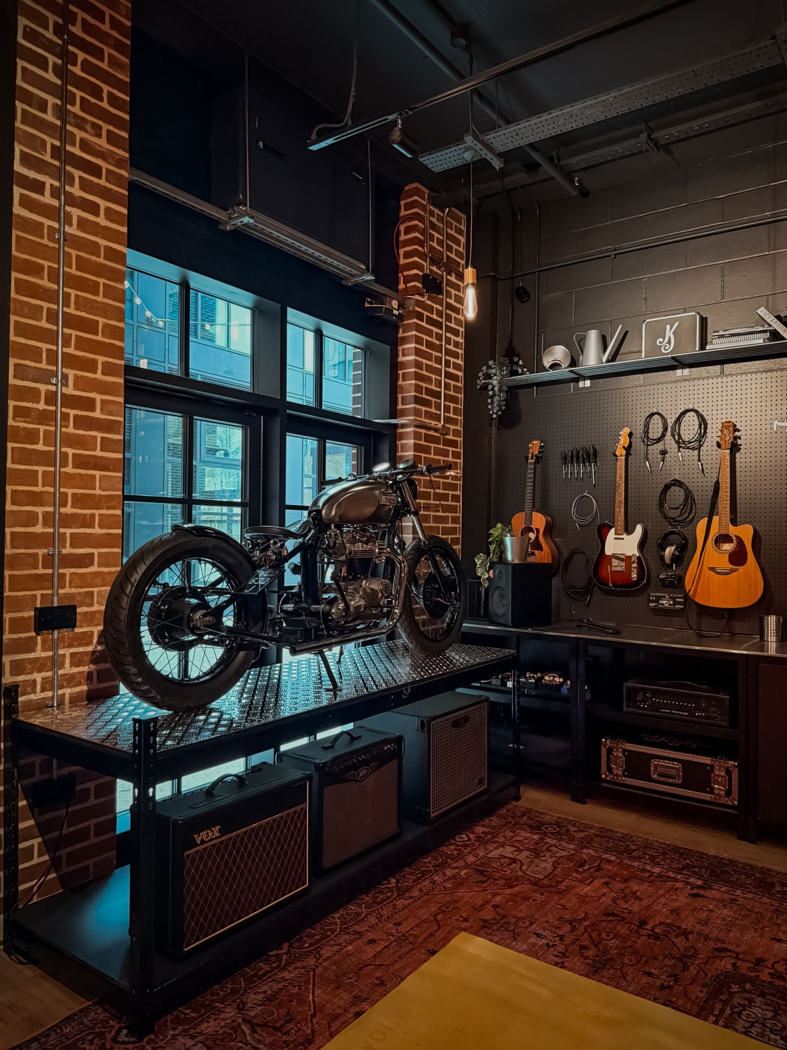 Motorcycles and guitars displayed in a stylish brick-walled industrial showroom