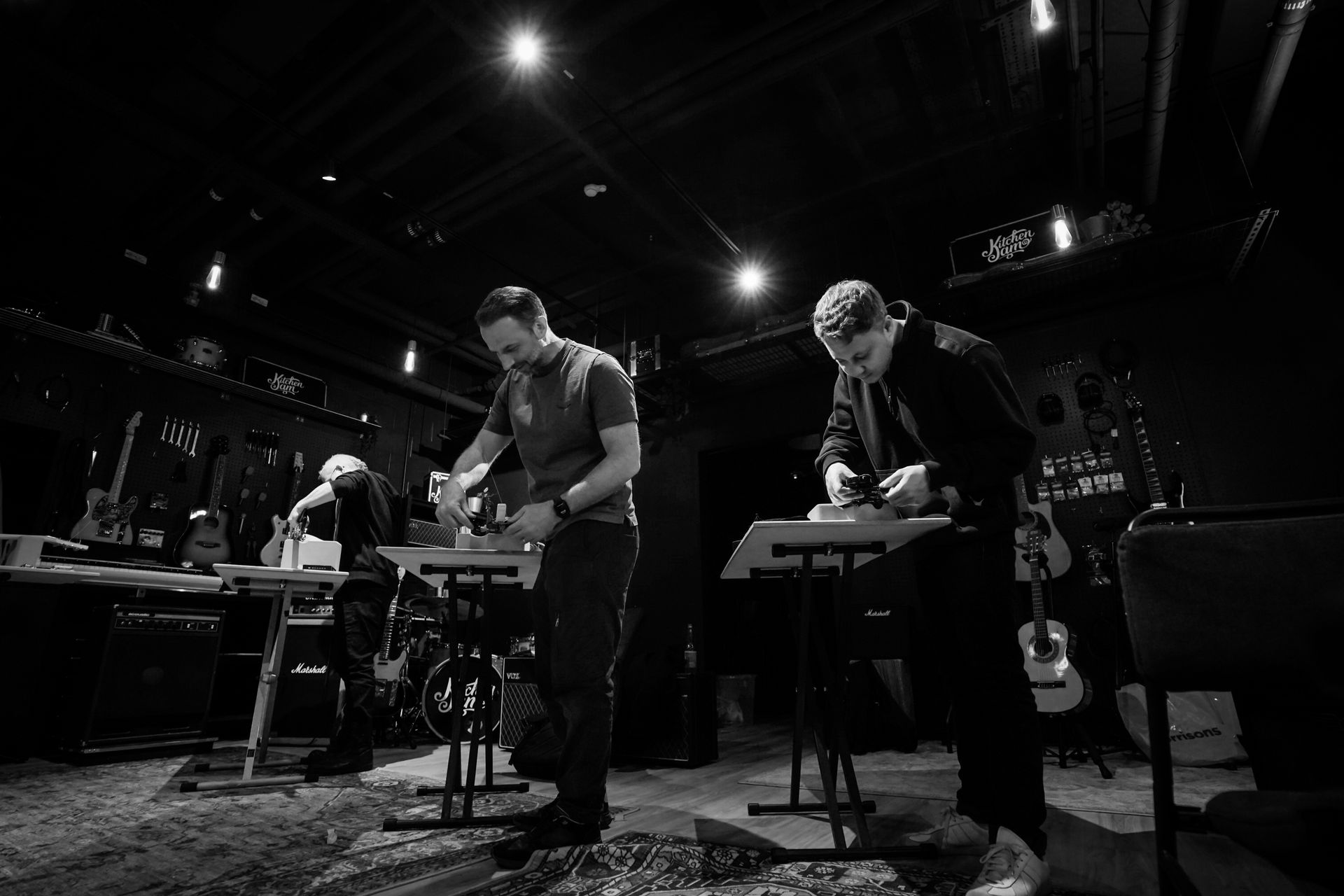 Guitar players setting up their guitars in a workshop