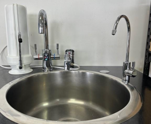 Stainless steel sink with three chrome faucets, a water filter, on a countertop. — NT Water Filters In Winnellie, NT