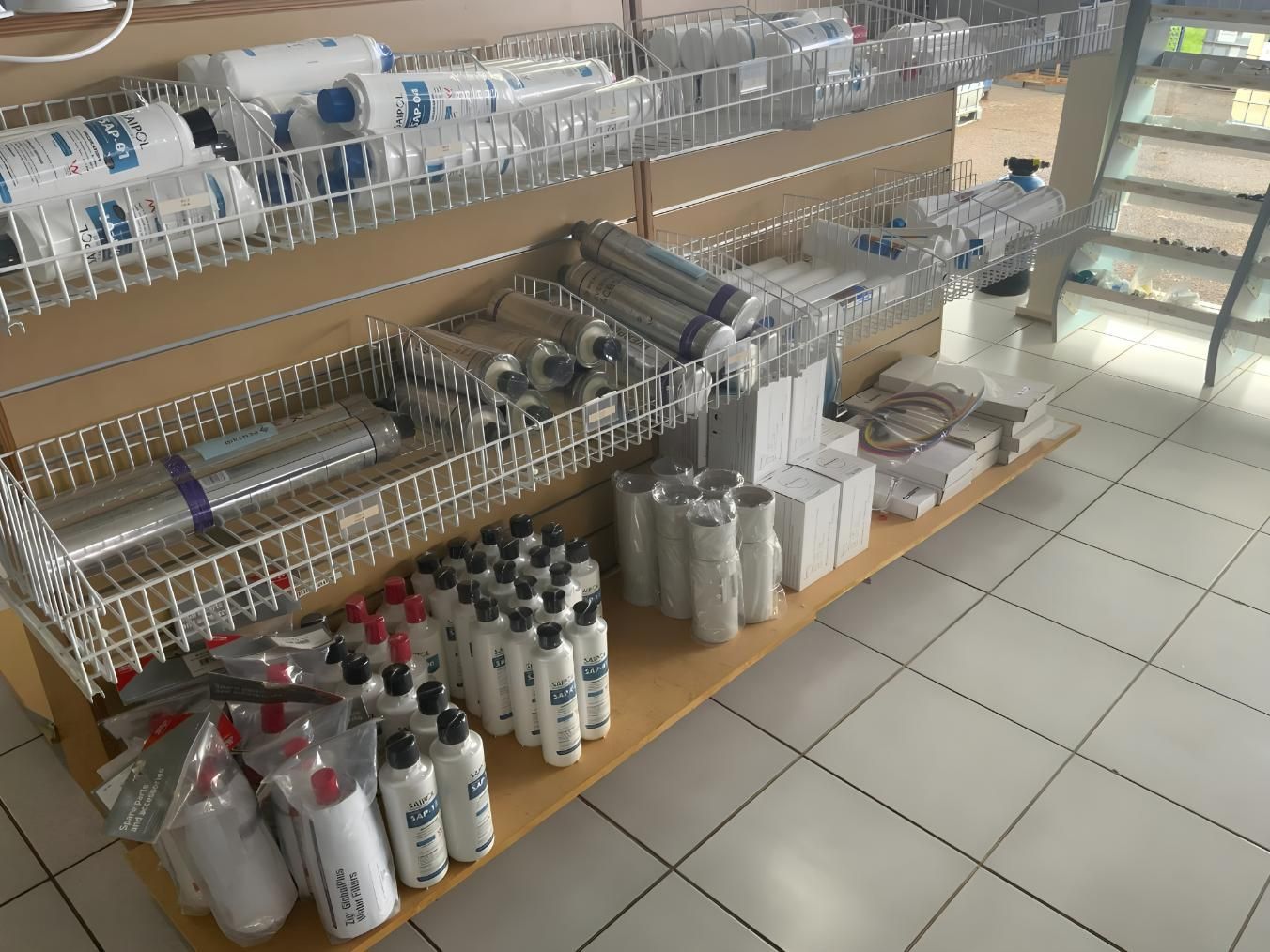 A Store Shelf Filled With Bottles and Rolls of Plastic Wrap — NT Water Filters In Winnellie, NT