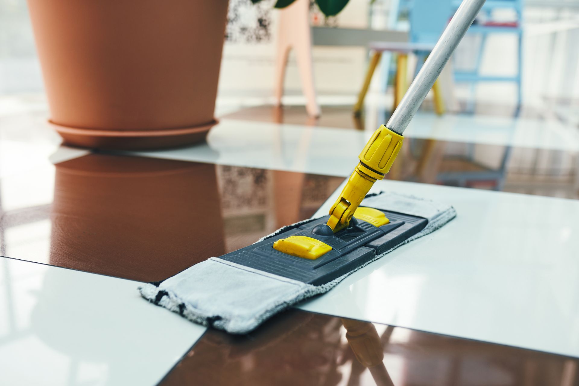 A mop is being used to clean a tiled floor.